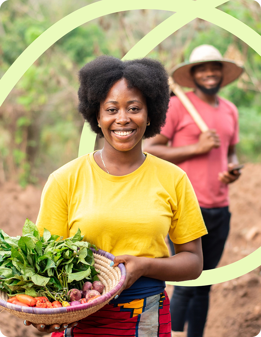 A woman in the countryside with a basket full of fresh vegetables.
