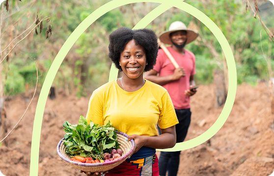 A woman in the countryside with a basket full of fresh vegetables.