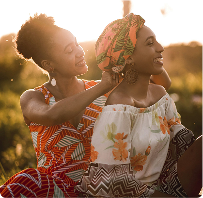 2 women sitting in the sun and laughing