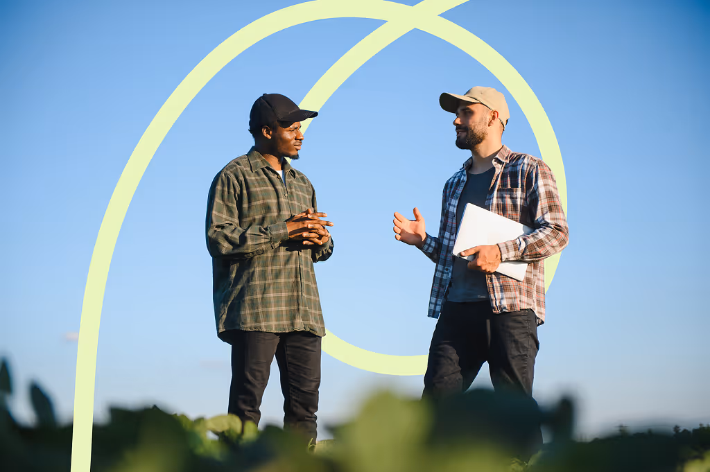 Two farmers in a field examining soy 