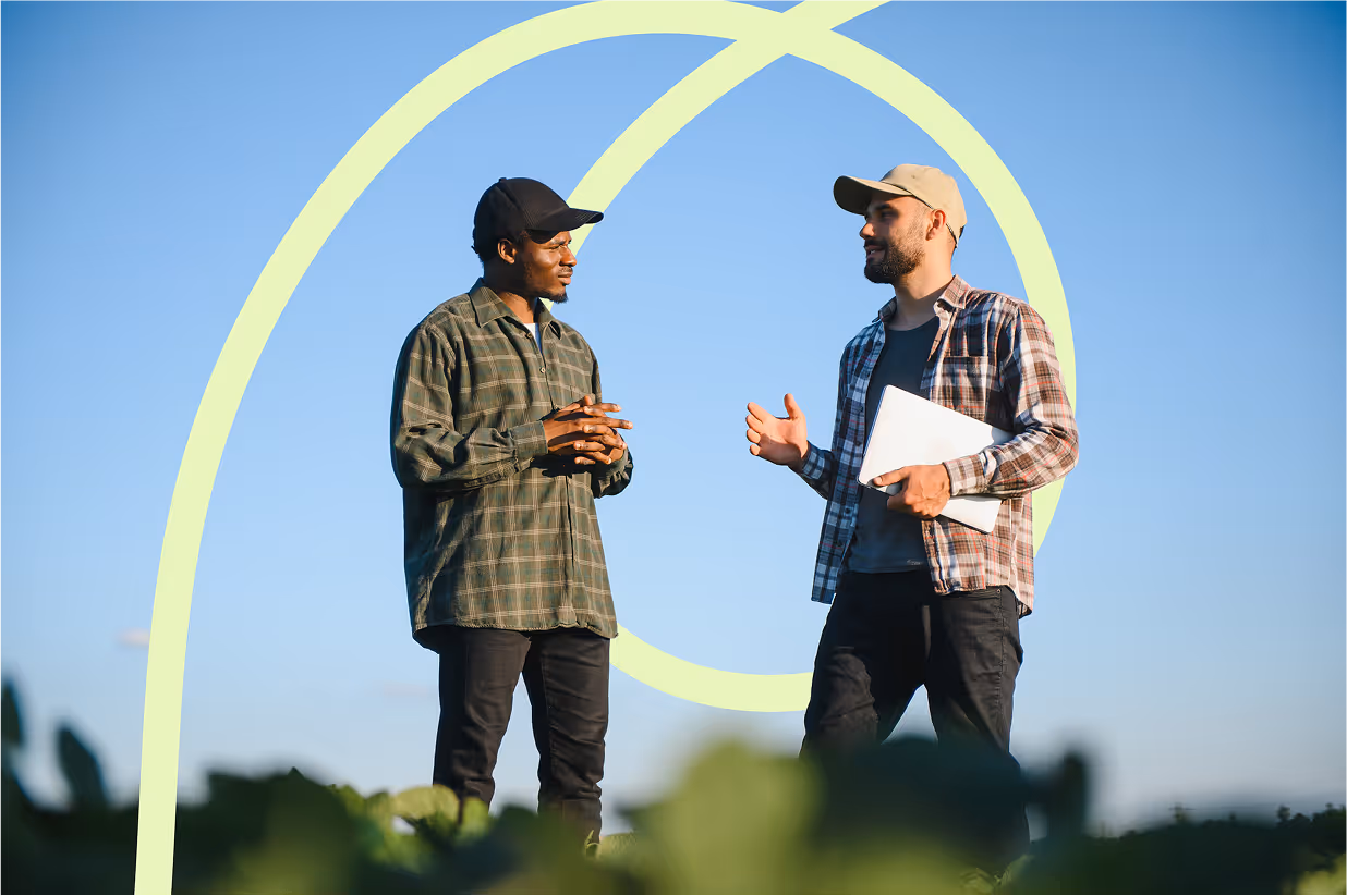 Two farmers in a field examining soy 