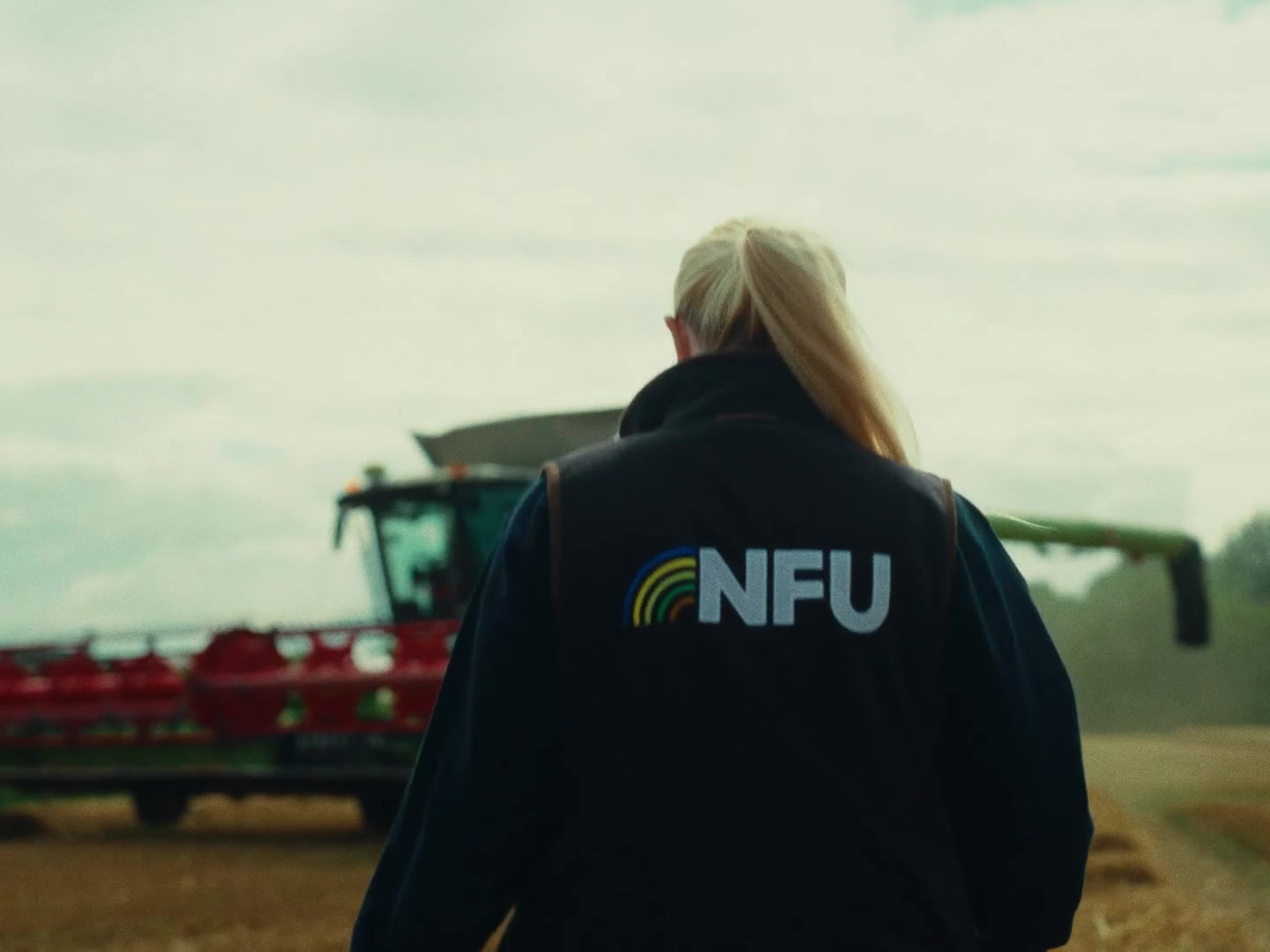NFU representative walking toward a combine harvester â the NFU arriving naturally within the world of farming