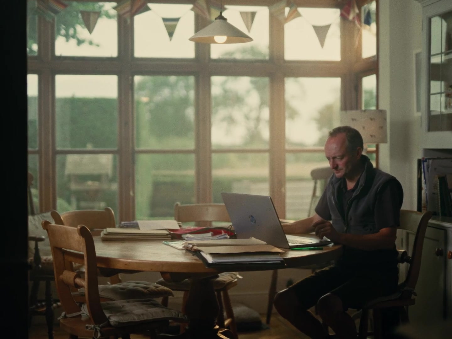 Farmer at kitchen table working through paperwork â one of the specific grounded moments in the film