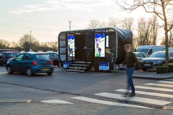An experiential digital screen set-up in a motorway service area carpark.