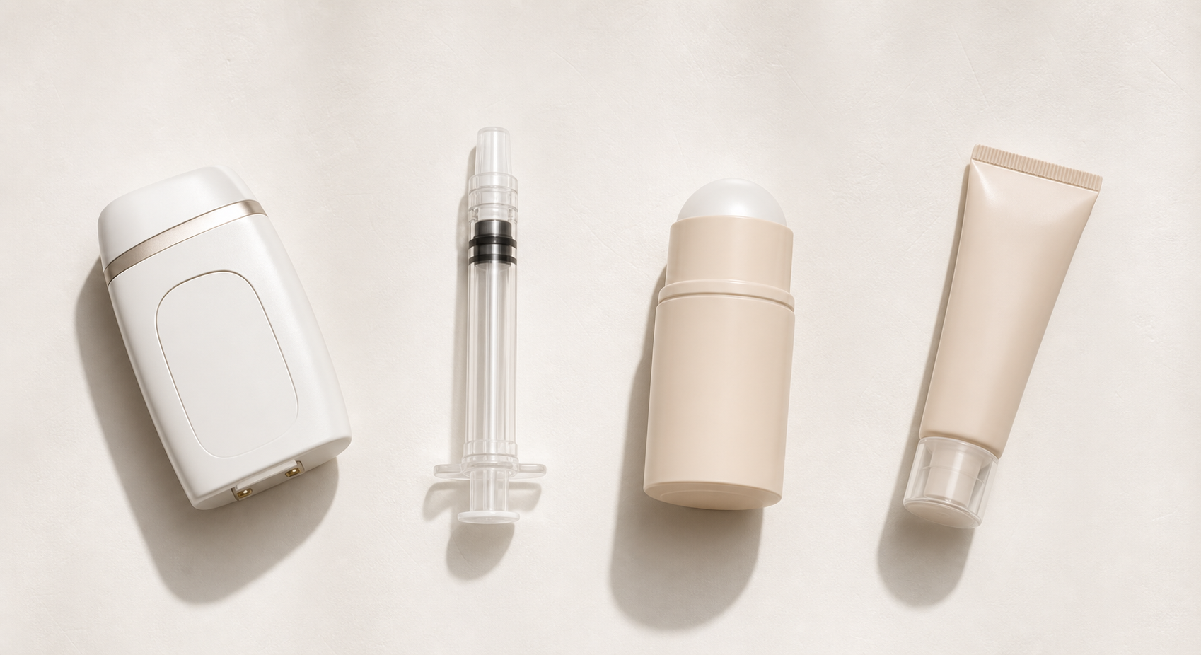 A clean flat-lay styled overhead arrangement of four distinct treatment items representing different hyperhidrosis options: a small clinical device, a syringe without a needle, a roll-on antiperspirant stick, and a small topical gel tube, each spaced evenly apart on a soft white background with subtle shadows, modern medical aesthetic, warm neutral tones