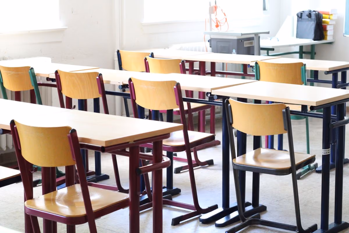 Helles Klassenzimmer mit Holztischen und Stühlen