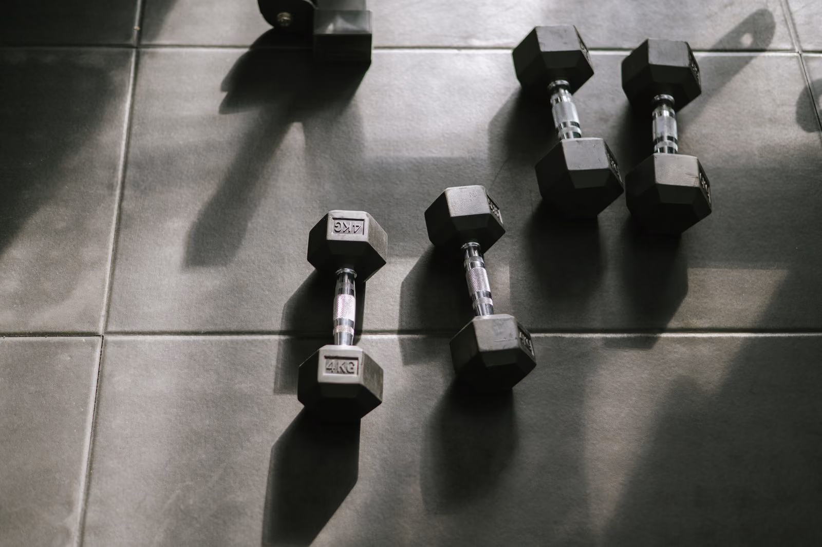 Hexagon-Hanteln im Sonnenlicht mit Schattenspiel im Fitnessstudio