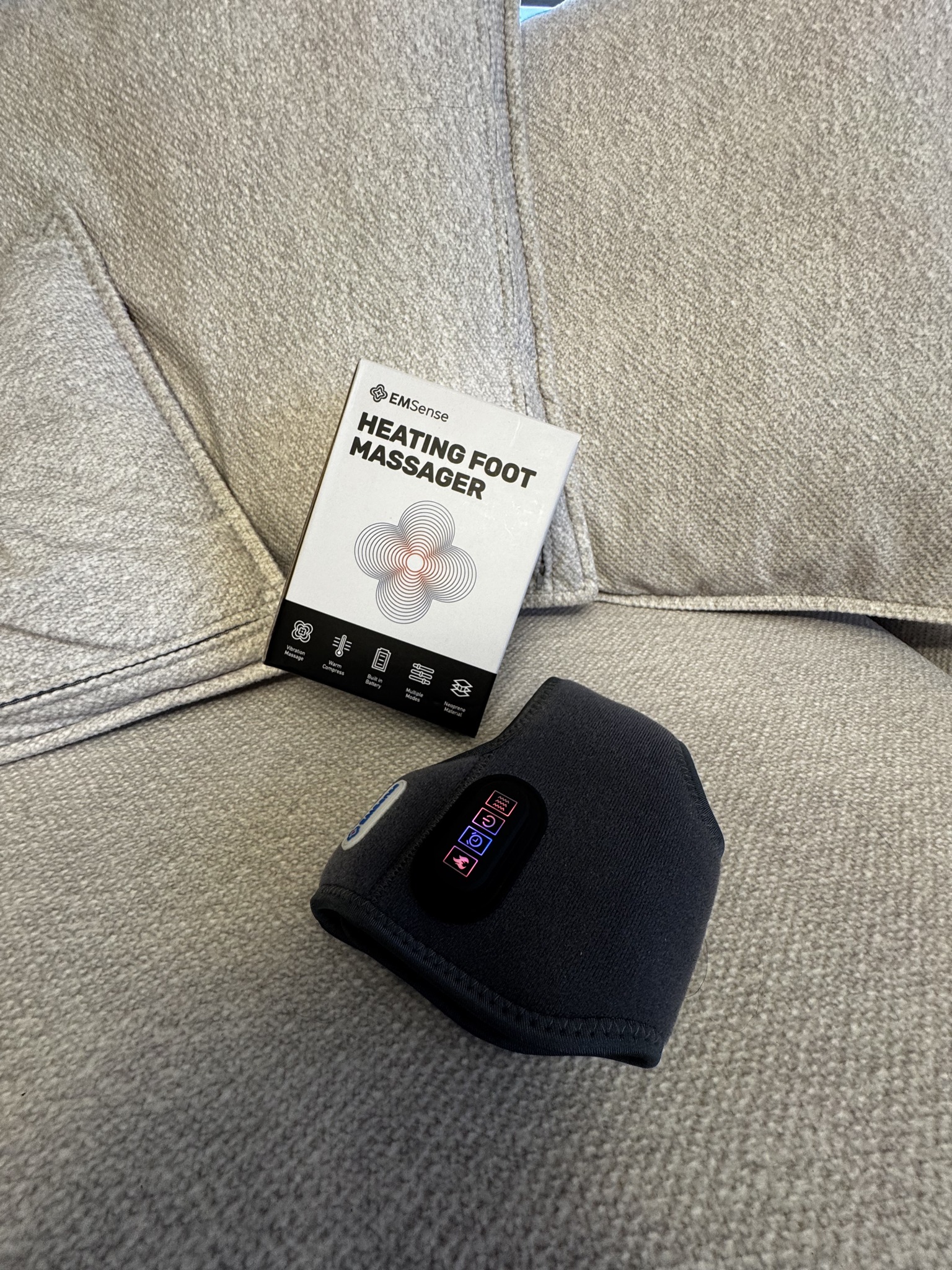 EMSense Heating Foot Massager and its box on a sofa