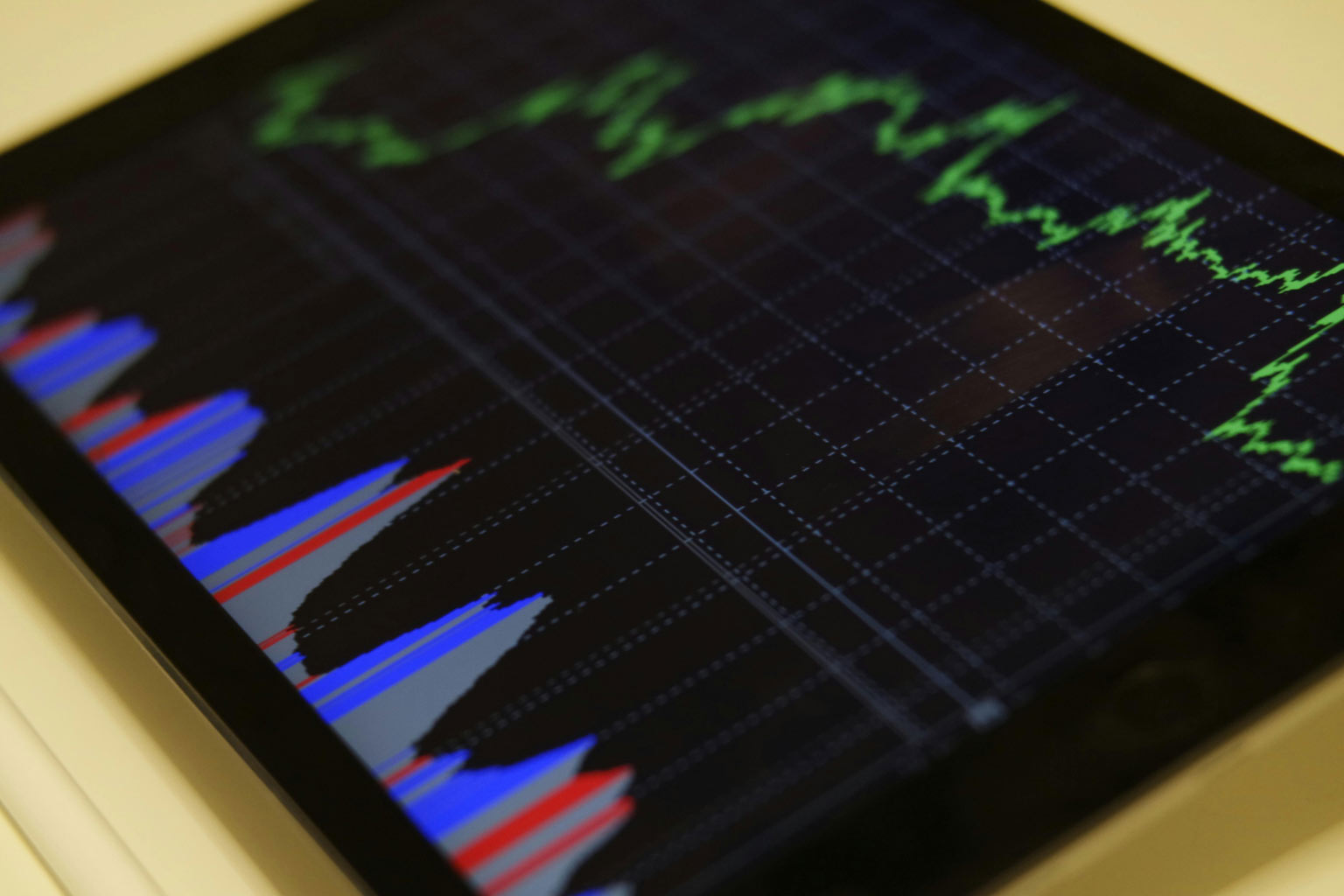 Close-up of a tablet displaying colorful bar and line graphs on a dark grid, representing digital coating thickness measurement data and potential interference.