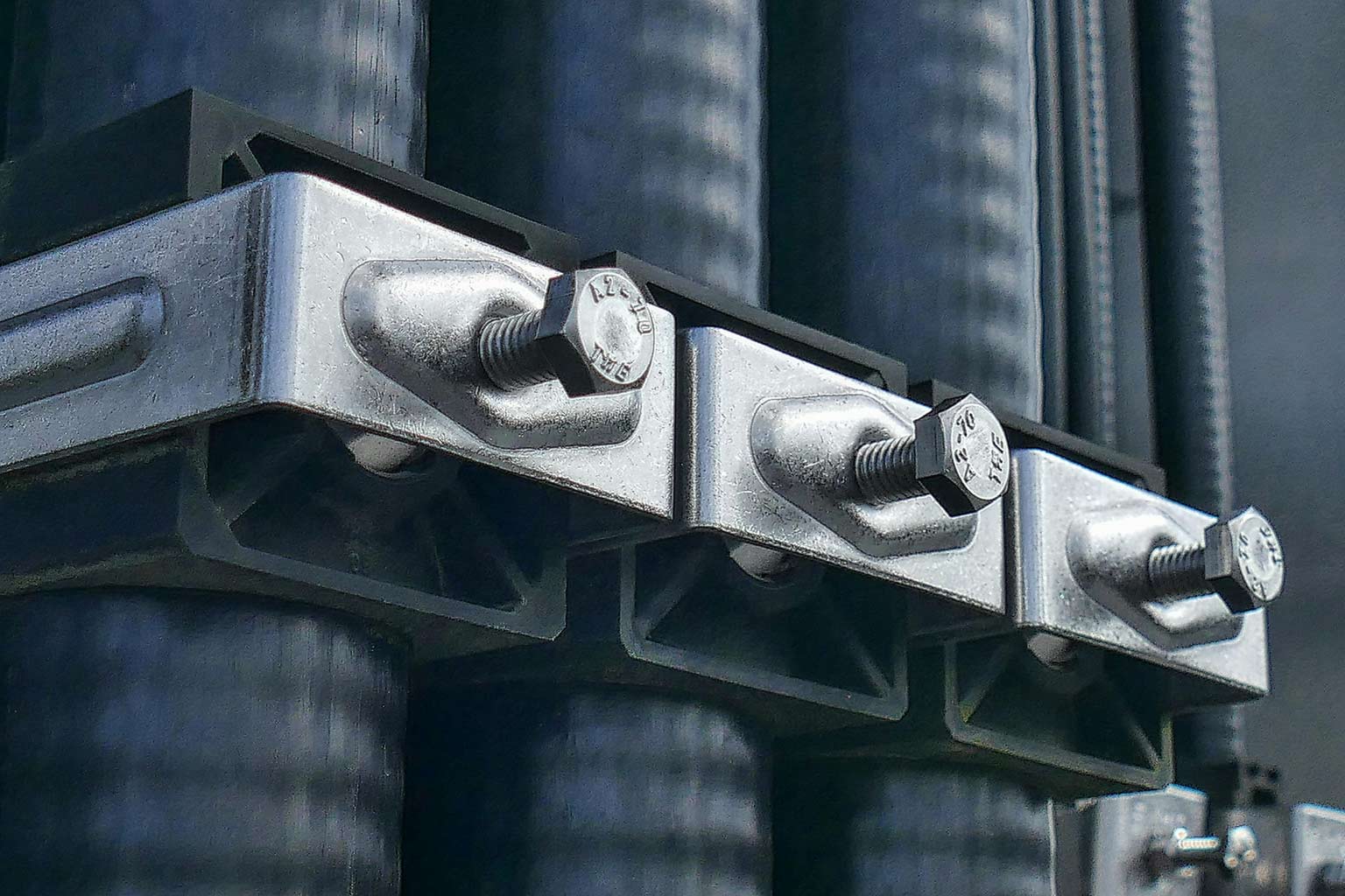 Close-up of galvanized fasteners installed in a metal bracket assembly, showing bolts and hardware coated for corrosion protection.