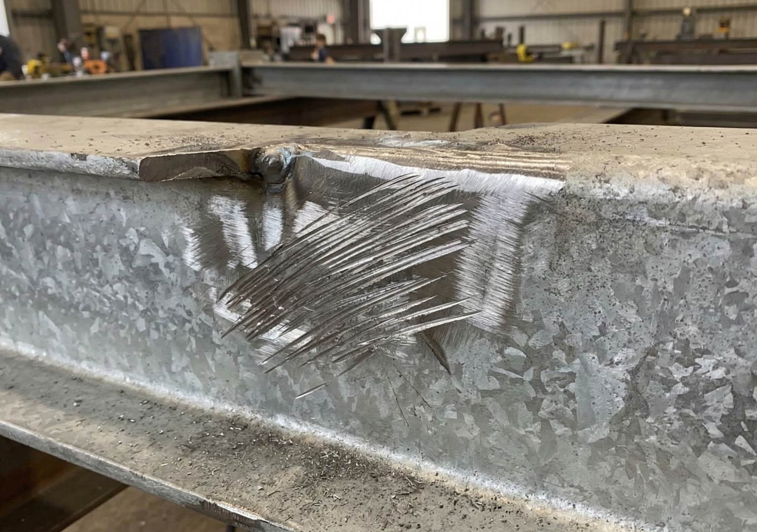 Hot dip galvanized steel surface showing visible grind marks after fabrication adjustment