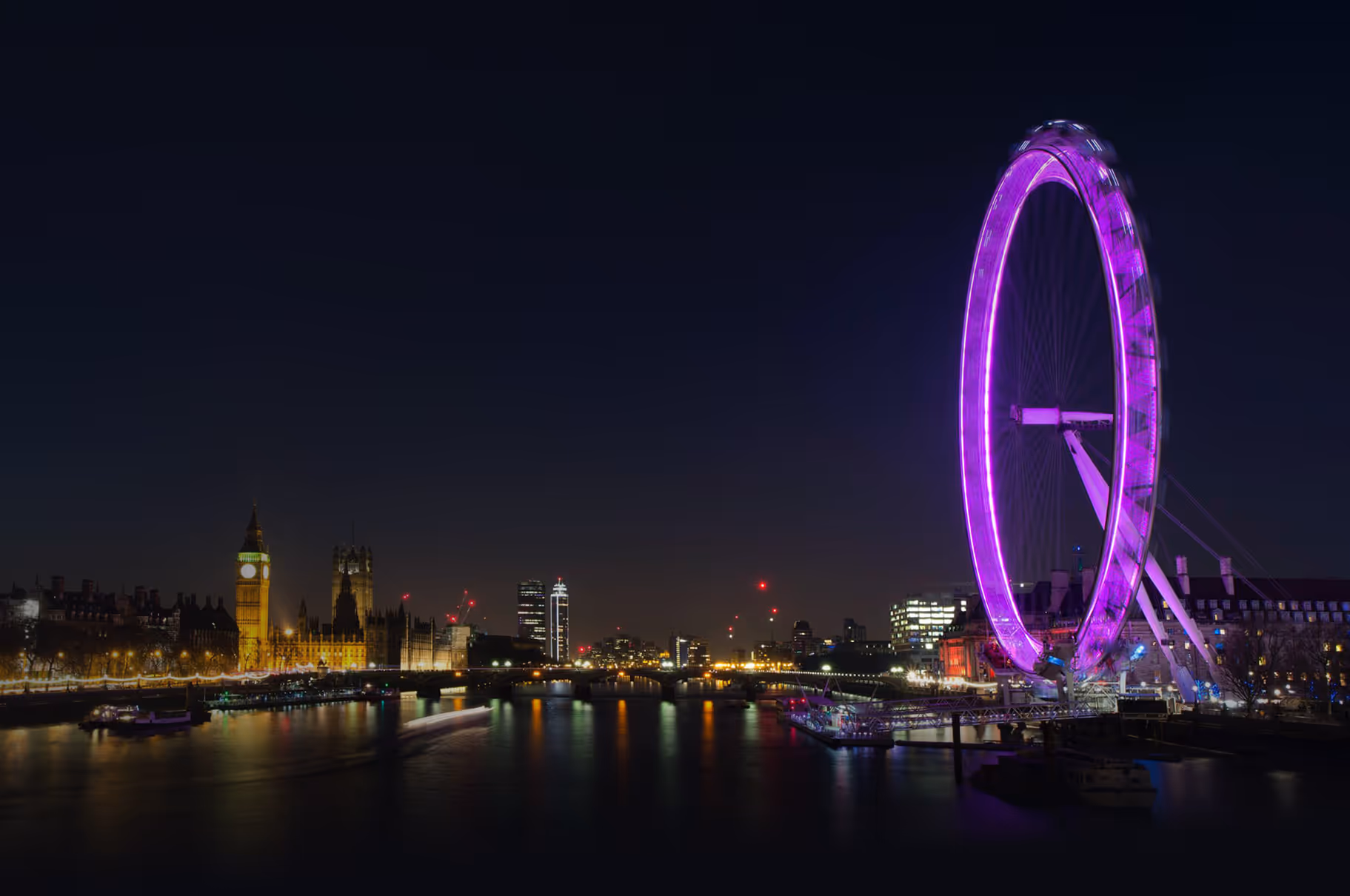 The London eye lit up in purple and pink