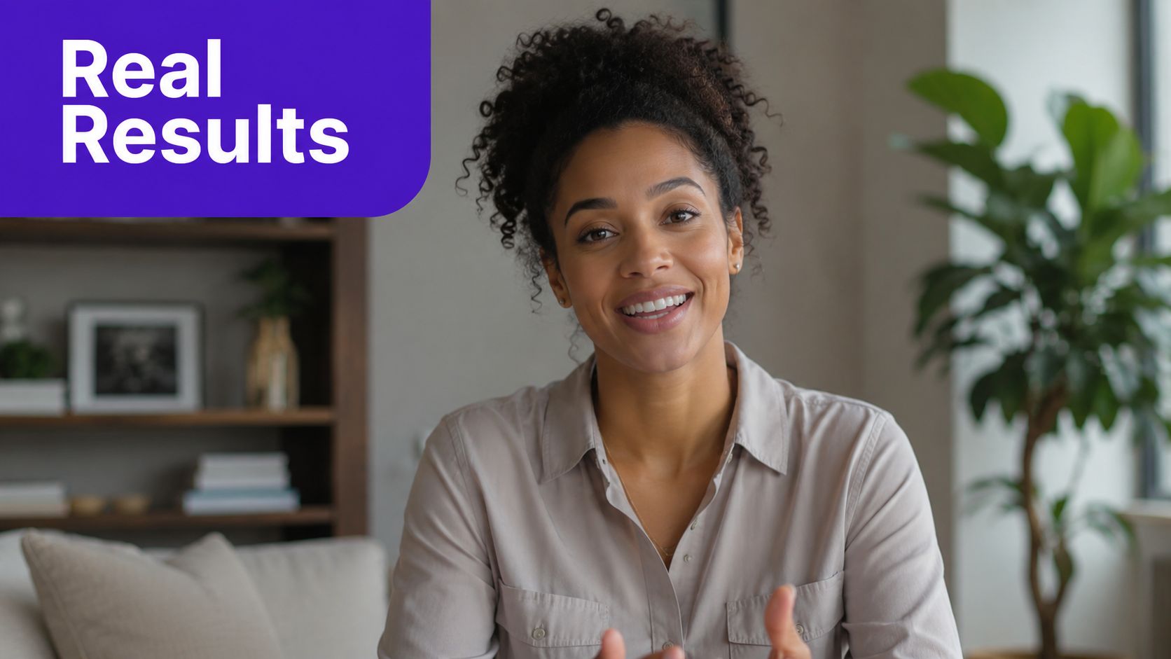 A woman with curly hair smiling while participating in a video call or recording a video.