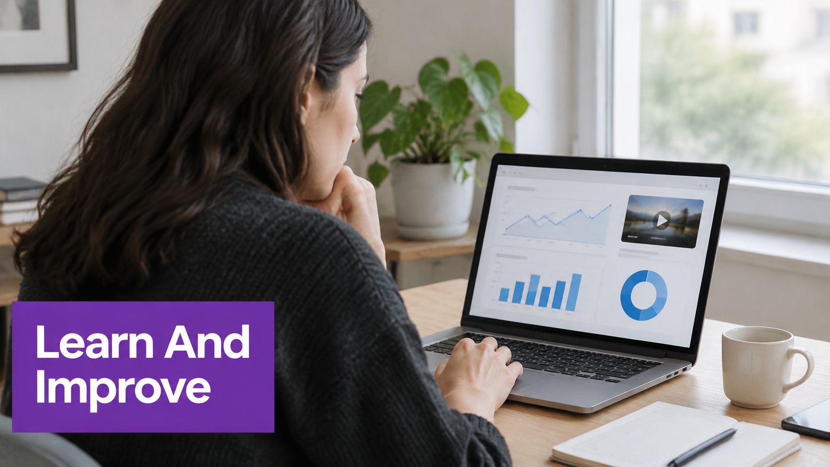 A professional woman reviews video analytics and performance charts on her laptop screen in a home office.