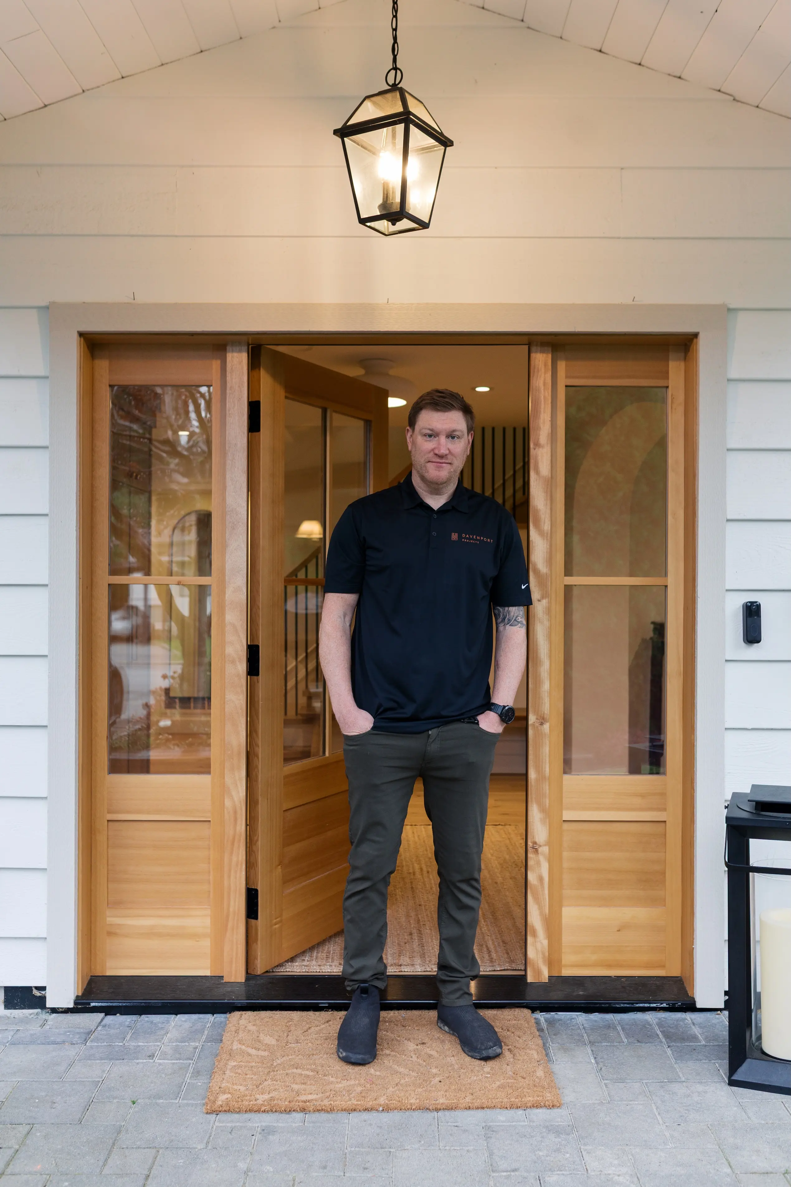 Kiff Mowat standing in the wood-framed front doorway of a Davenport home
