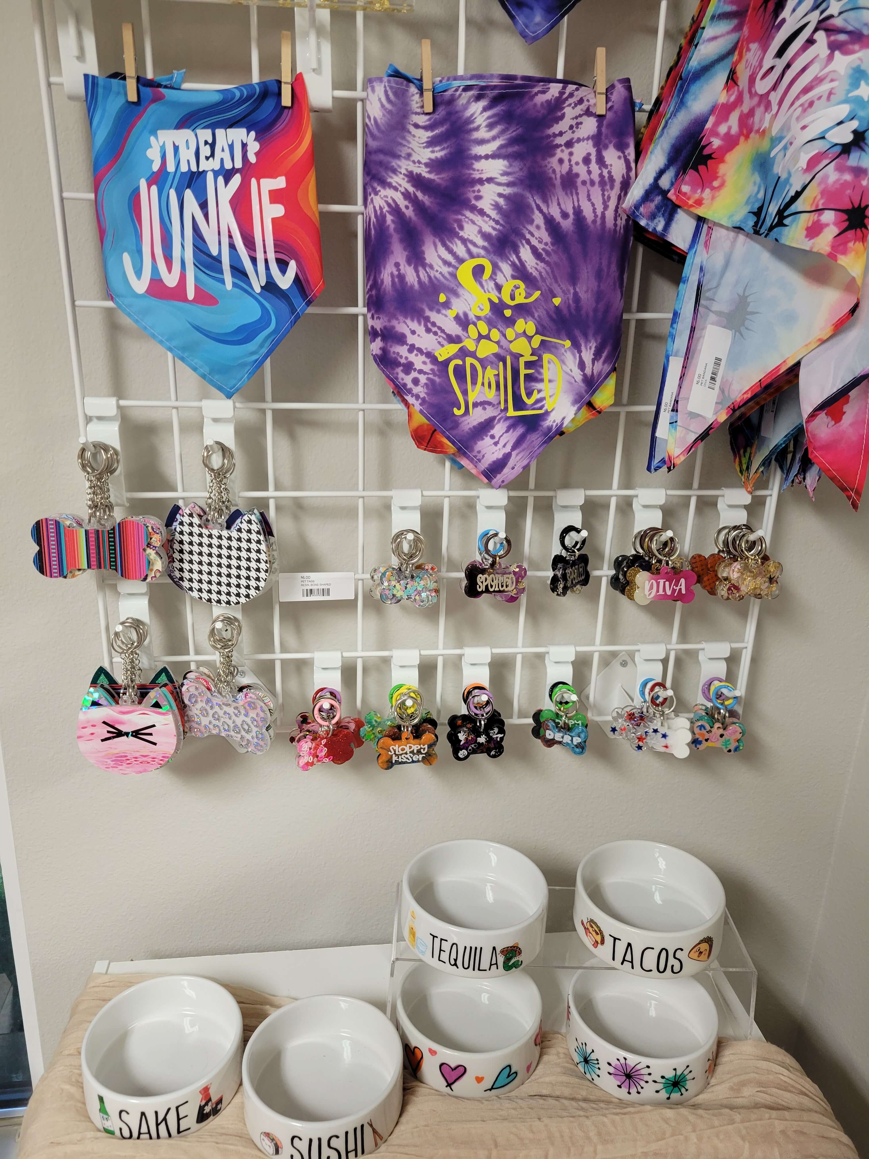 Display of crystal keychains, beaded bracelets, rings, and polished stones on a wooden table.
