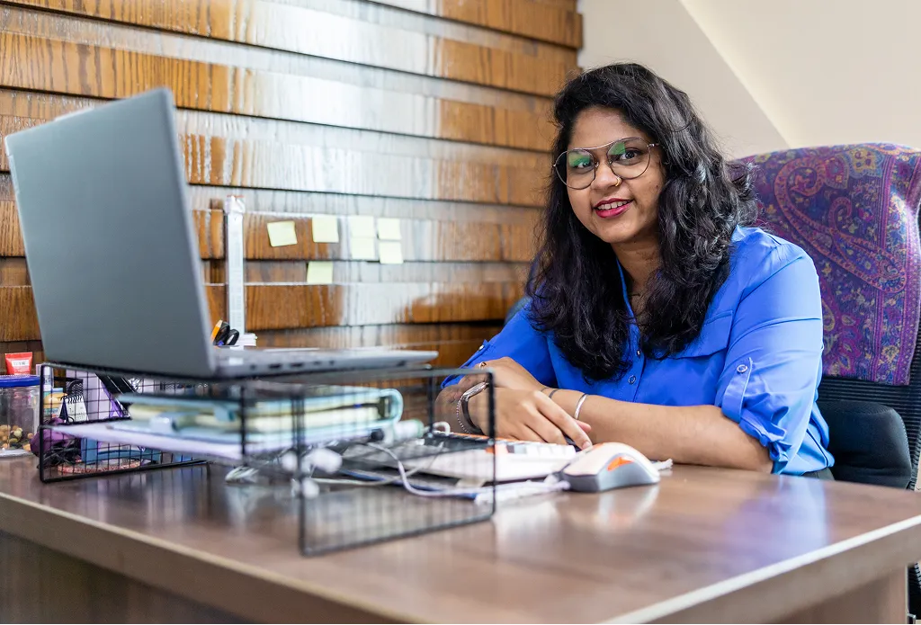 Arka Navle, legal advisor at Kayrouz & Associates, working at her desk in a modern office setting.