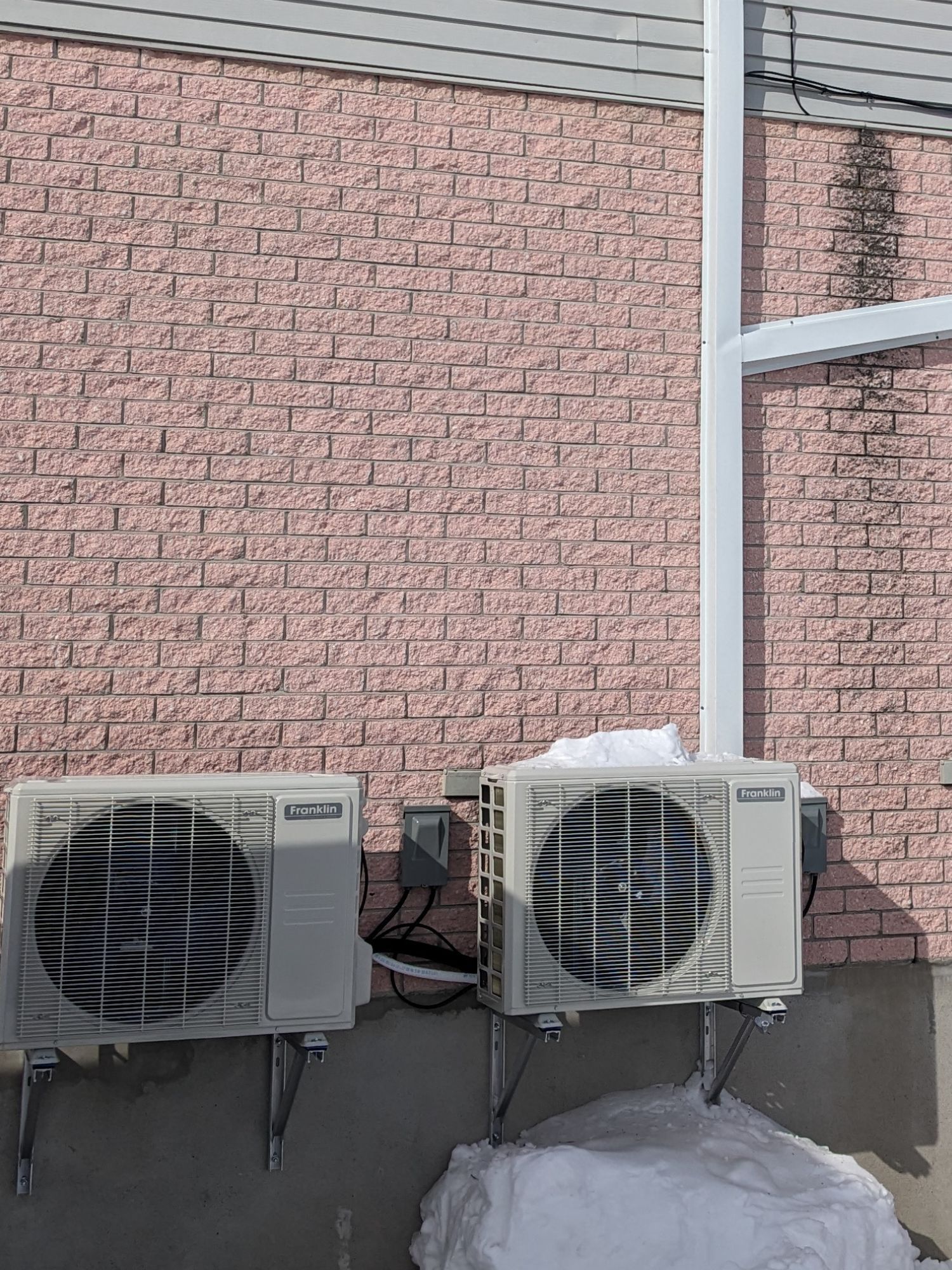 photo de deux thermopompes murales installées sur un duplex en brique