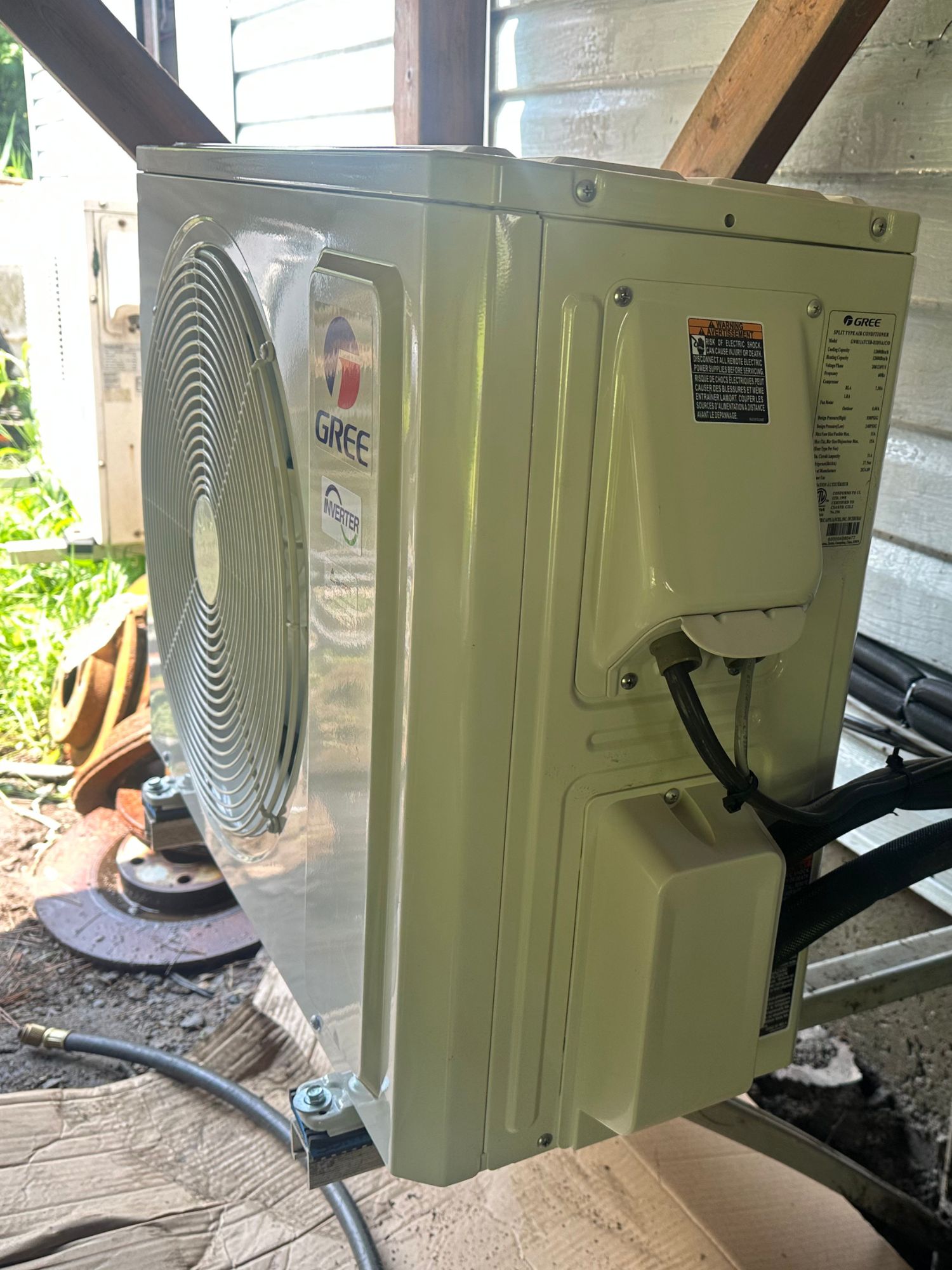 Thermopompe Gree Vita installée sous le balcon d'une maison