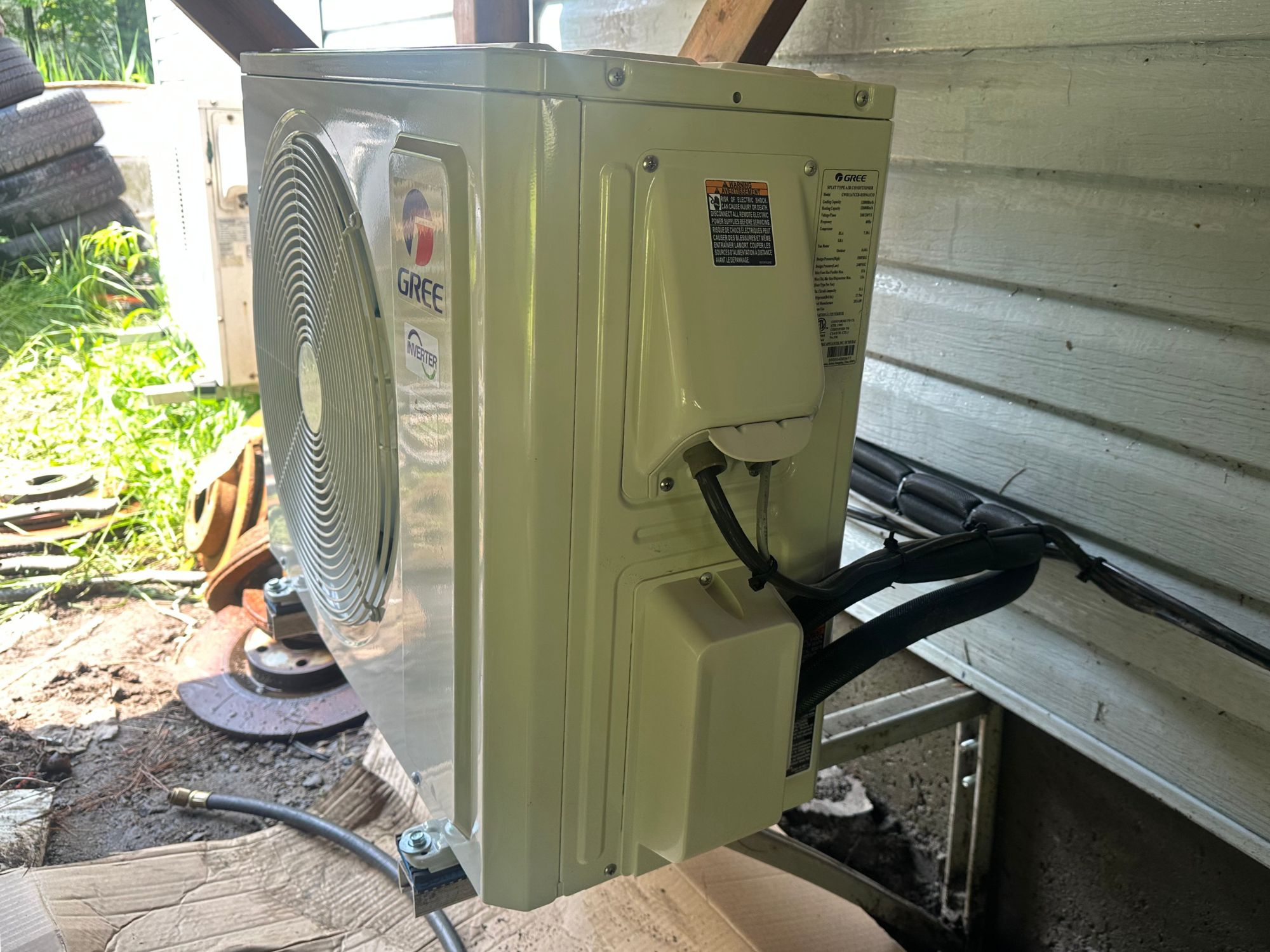 Thermopompe Gree Vita installée sous le balcon d'une maison