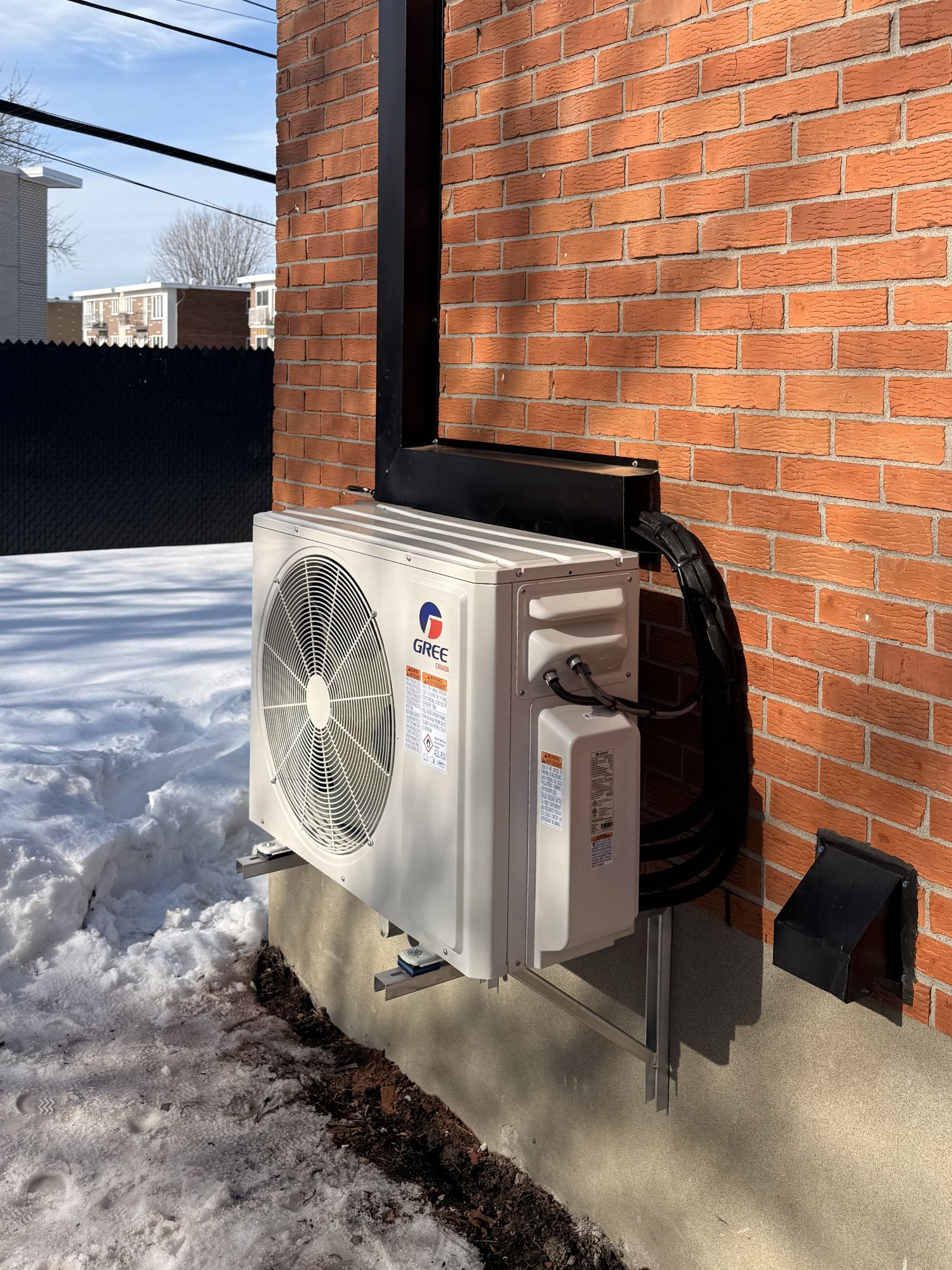 Thermopompe installée sur un mur de brique
