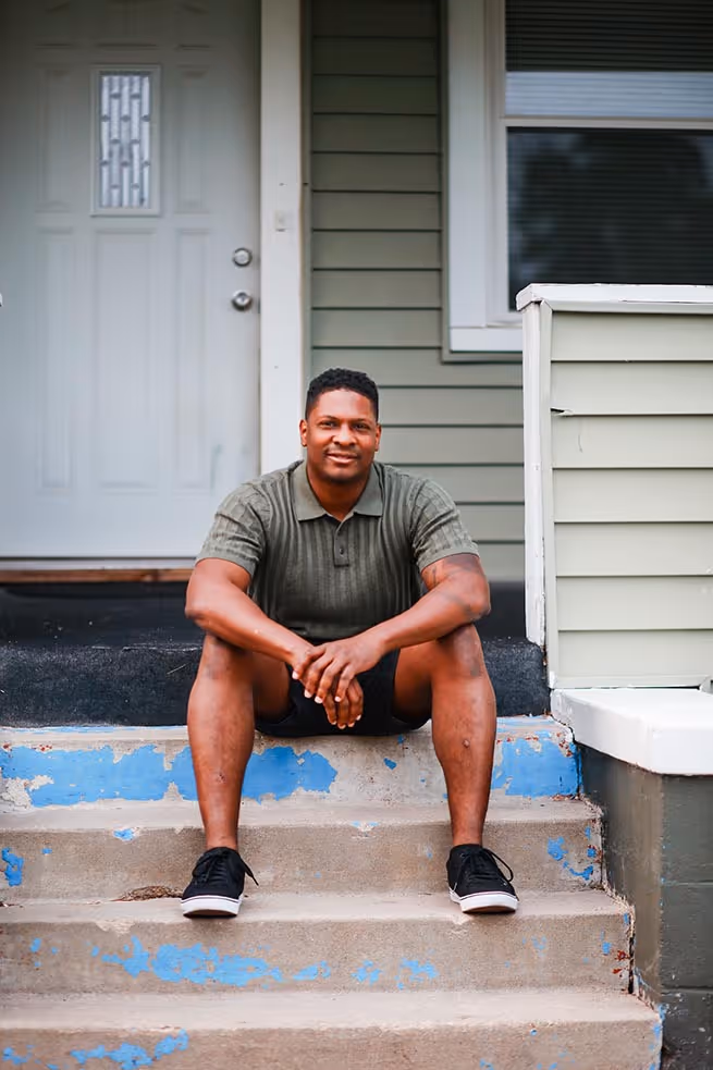 A man sitting on the steps of a house.