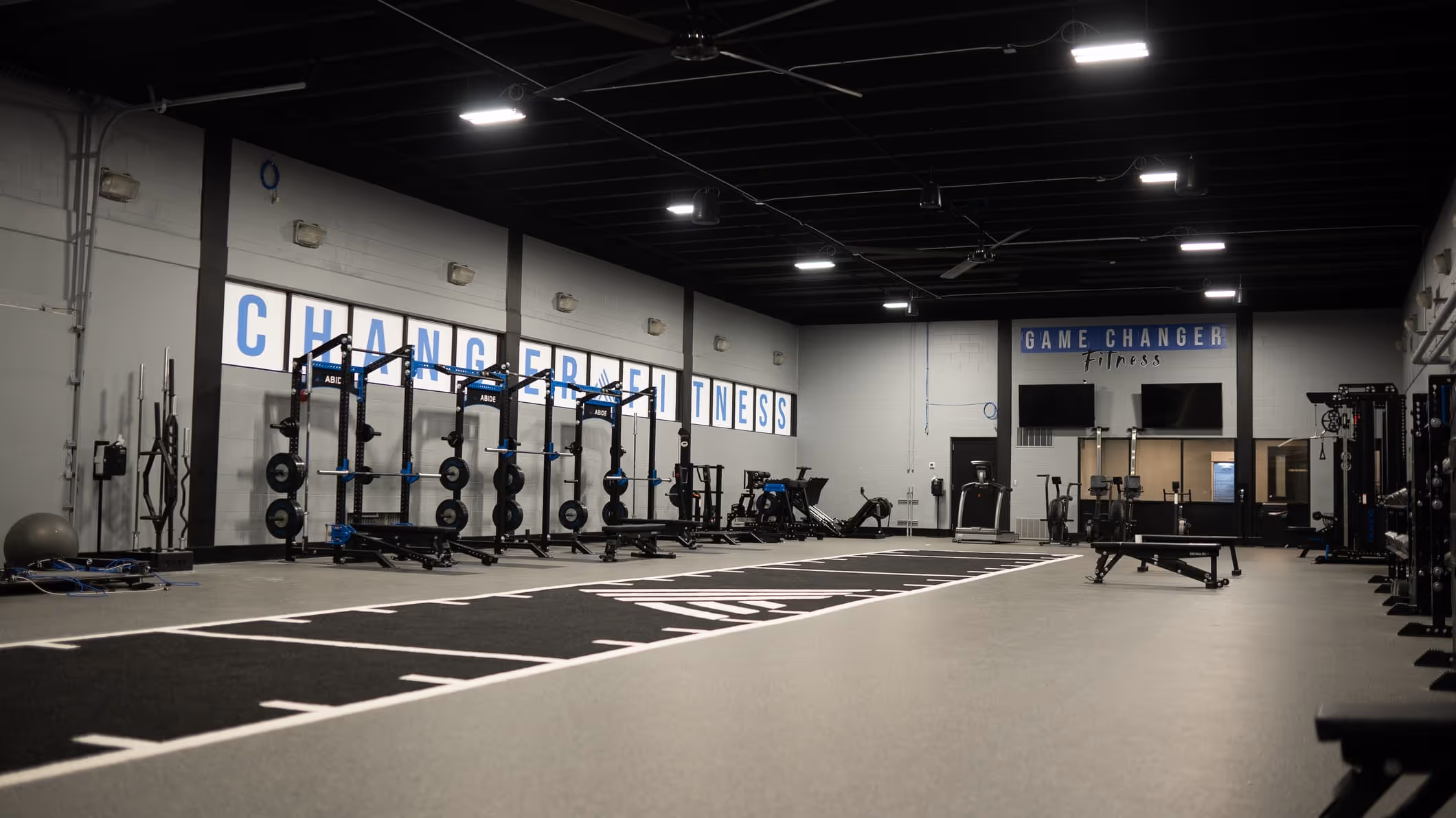 A gym with a row of exercise equipment.