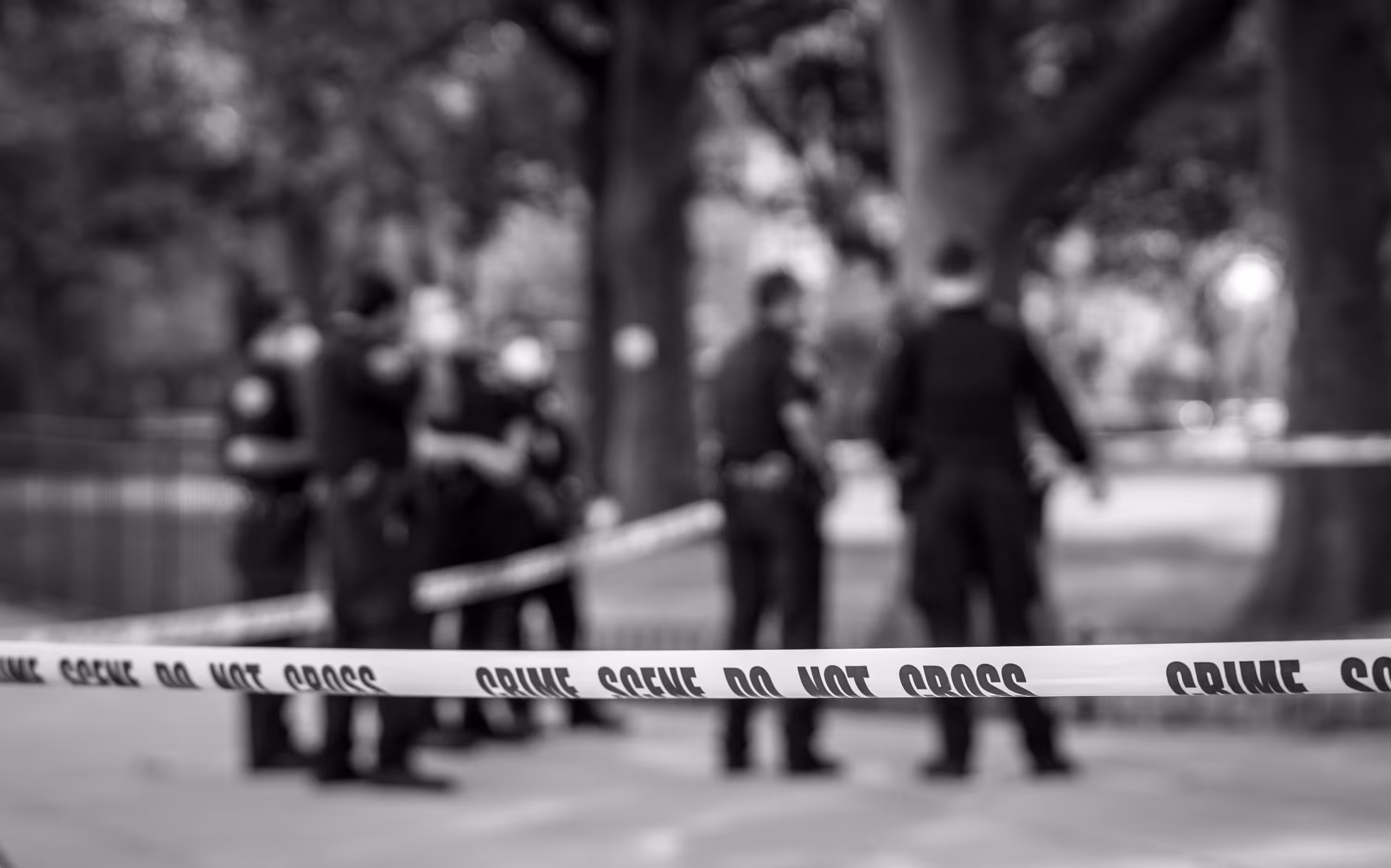 A police cord is in front of a bench.