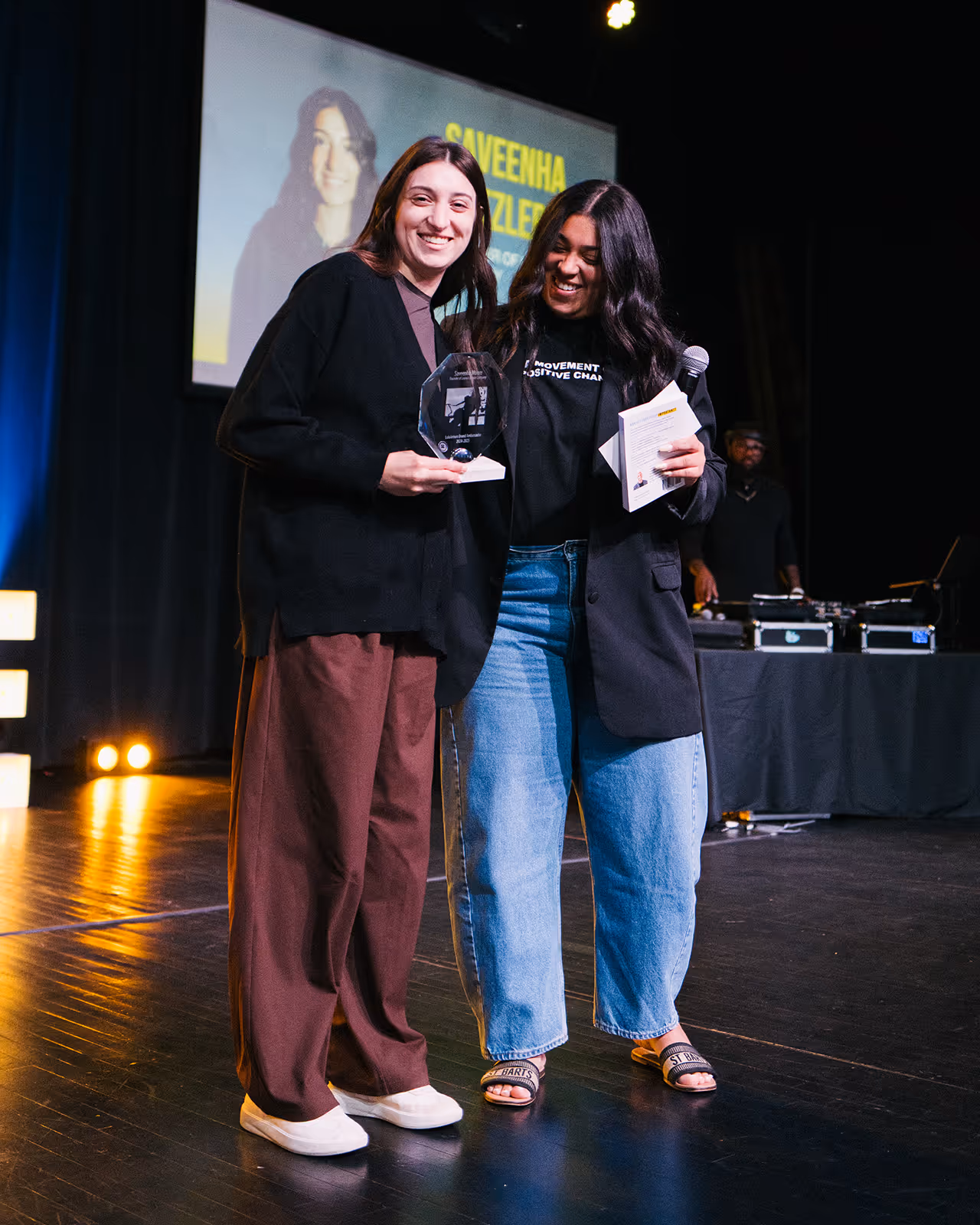 Two women standing next to each other on a stage.