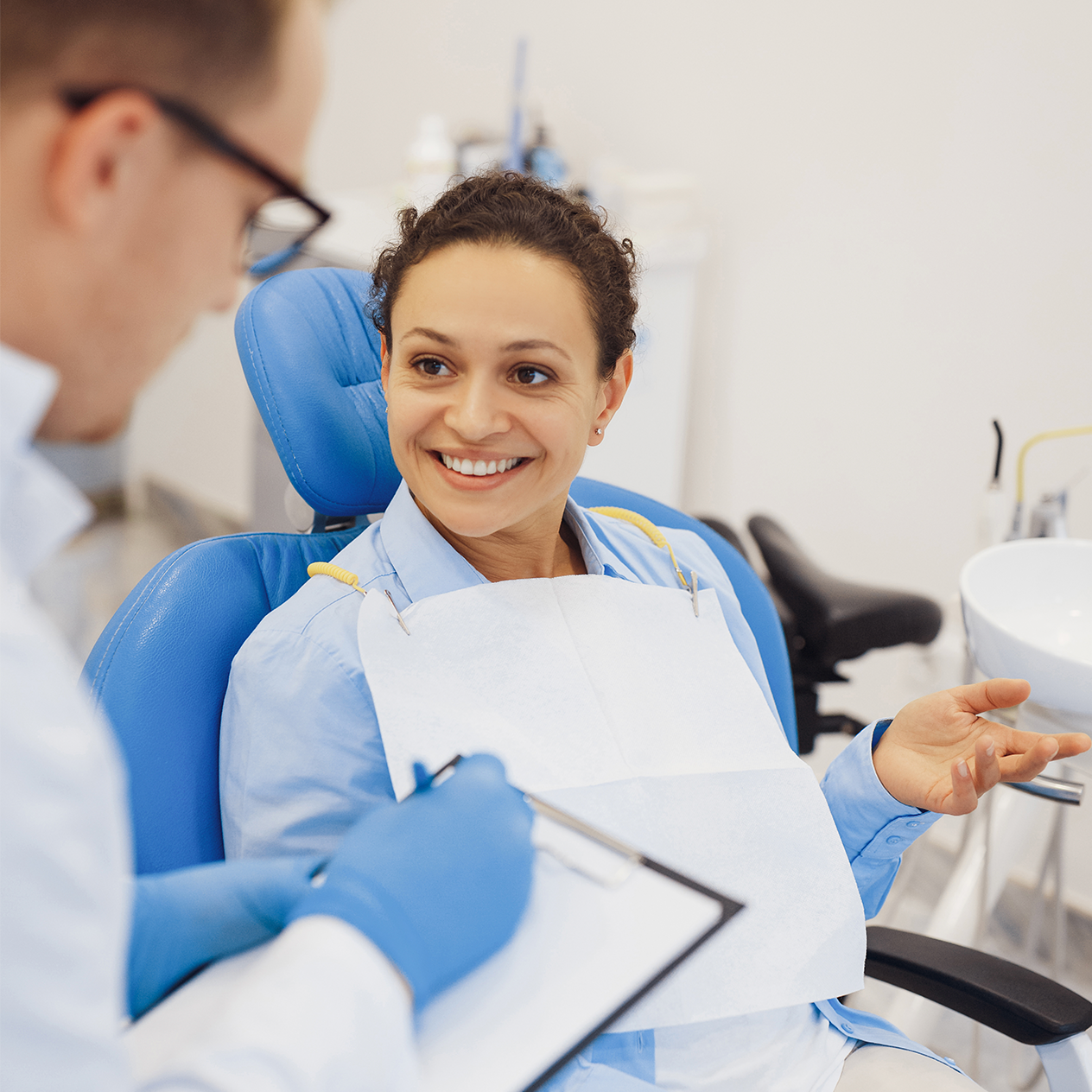 Lady sitting in a dental chair talking to the dentist
