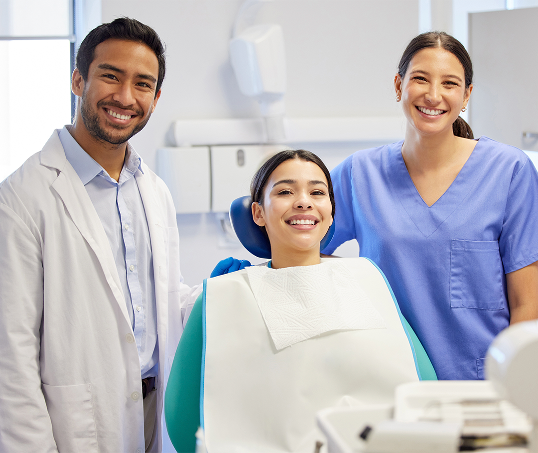 Smiling dentist, assistant and patient in the clinic