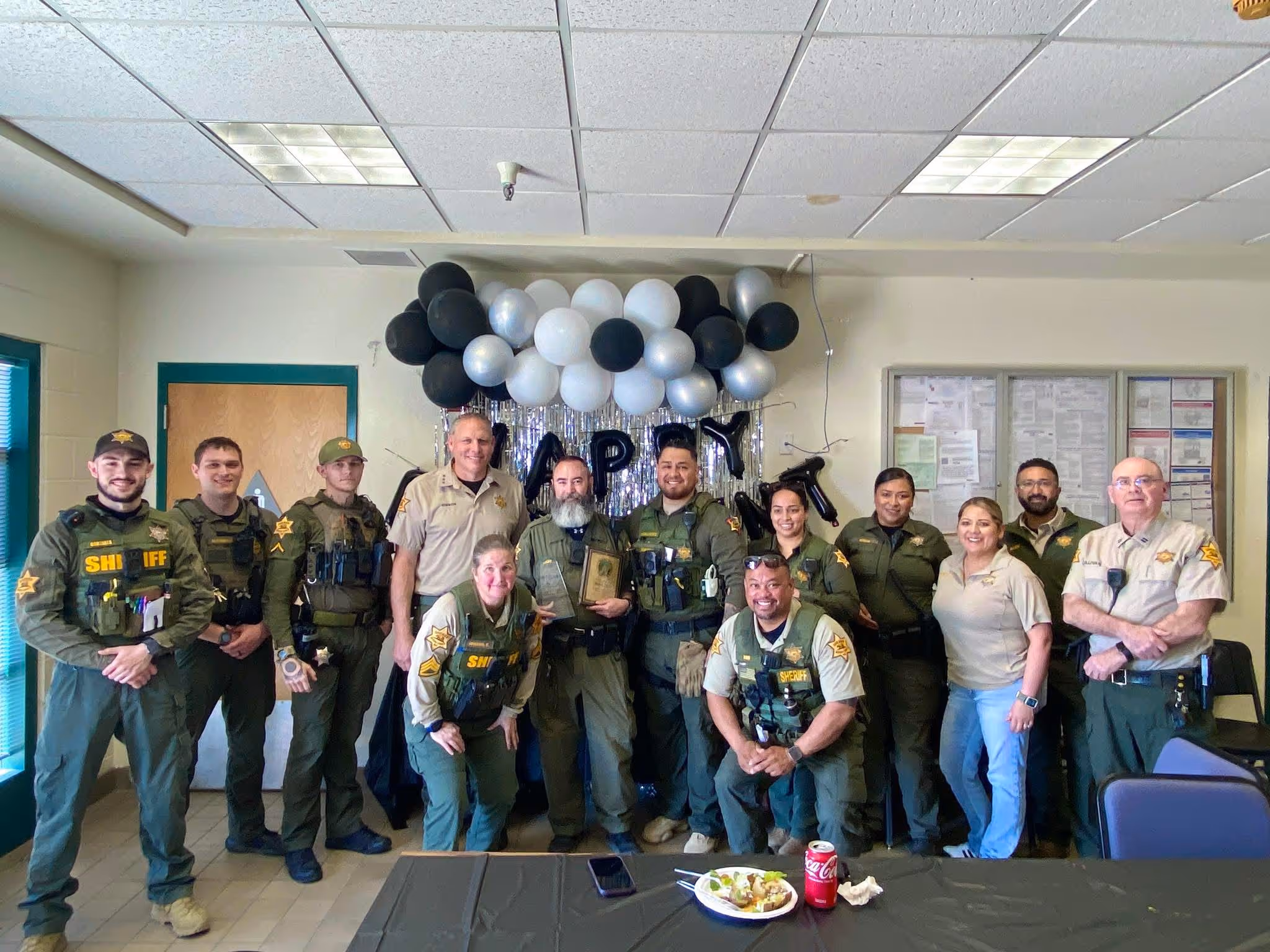 Merced County SCA's personnel celebrating a team member's recognition with balloons and a plaque