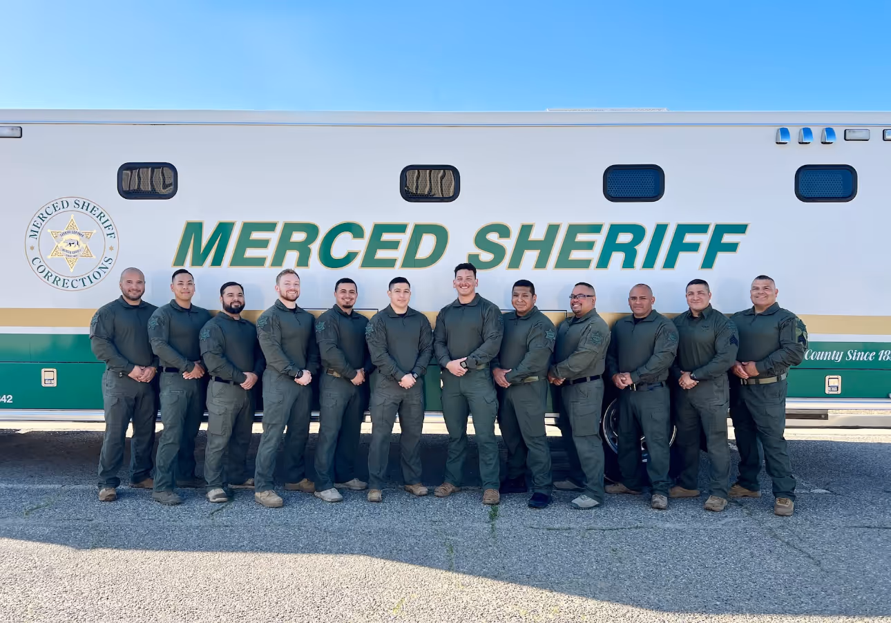 Merced County Sheriff's Corrections team posing in uniform in front of a mobile command unit