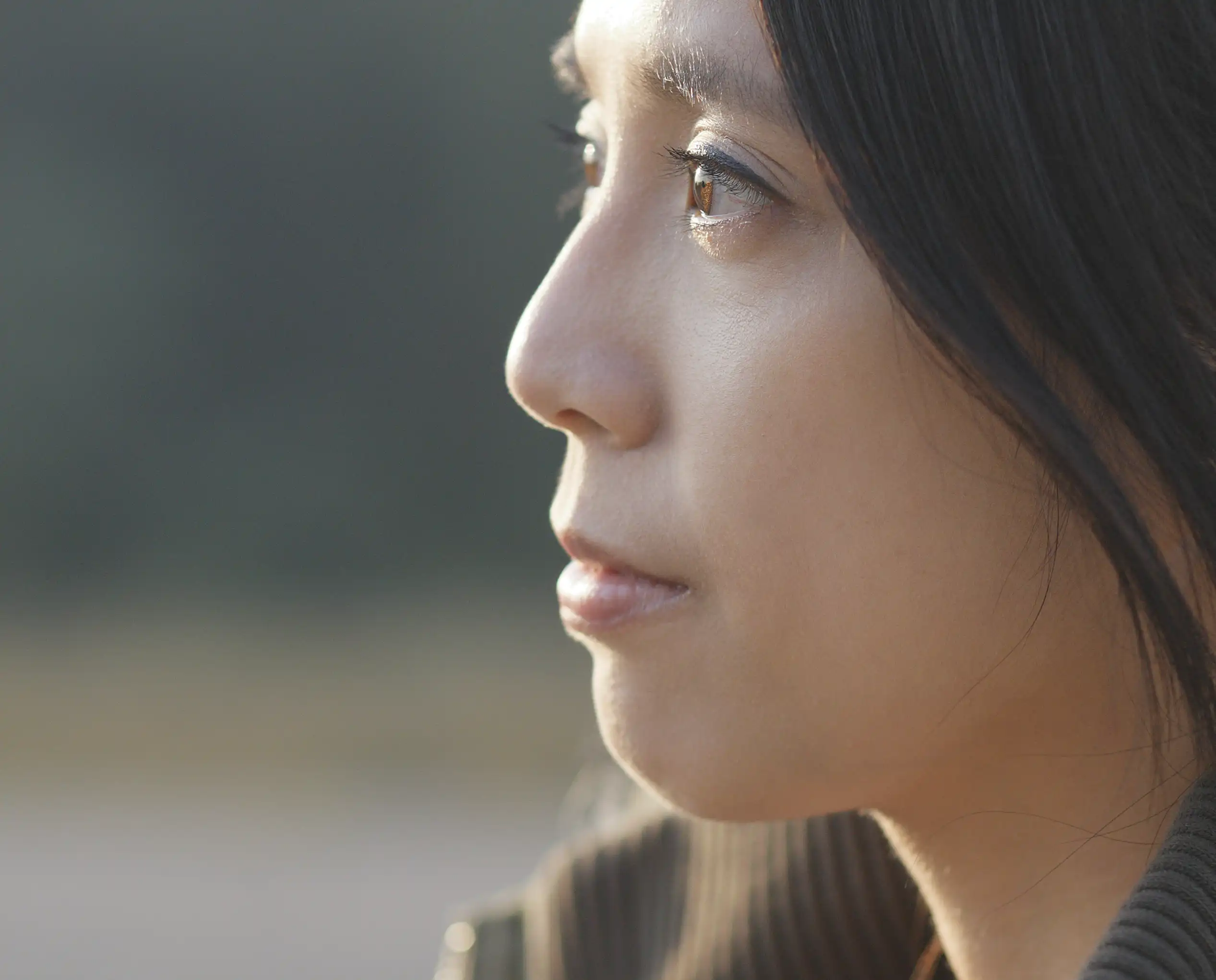 An Asian girl looking into the distance thinking