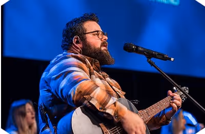 A man singing while playing guitar