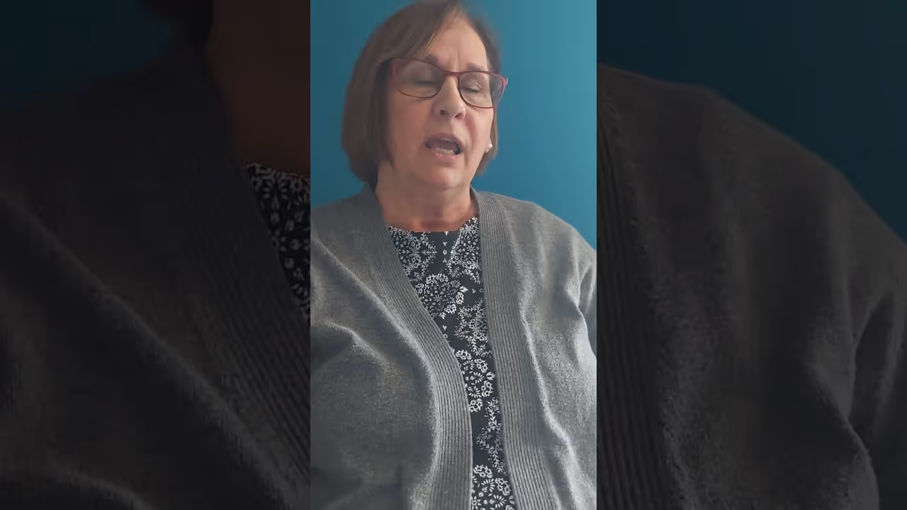 a woman with glasses and a grey sweater
