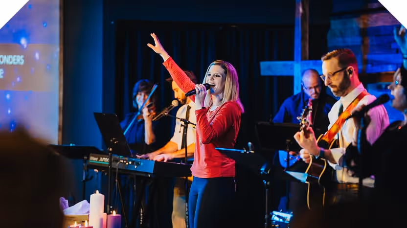 A worship singer raising her hand in praise