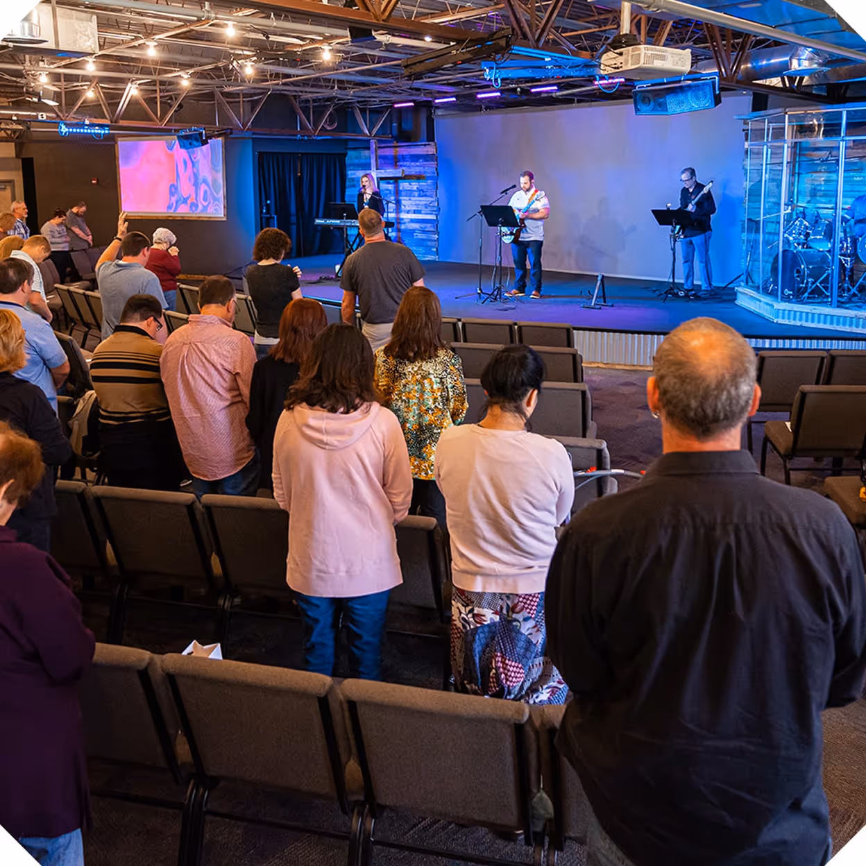 a group of people watching a man on a stage