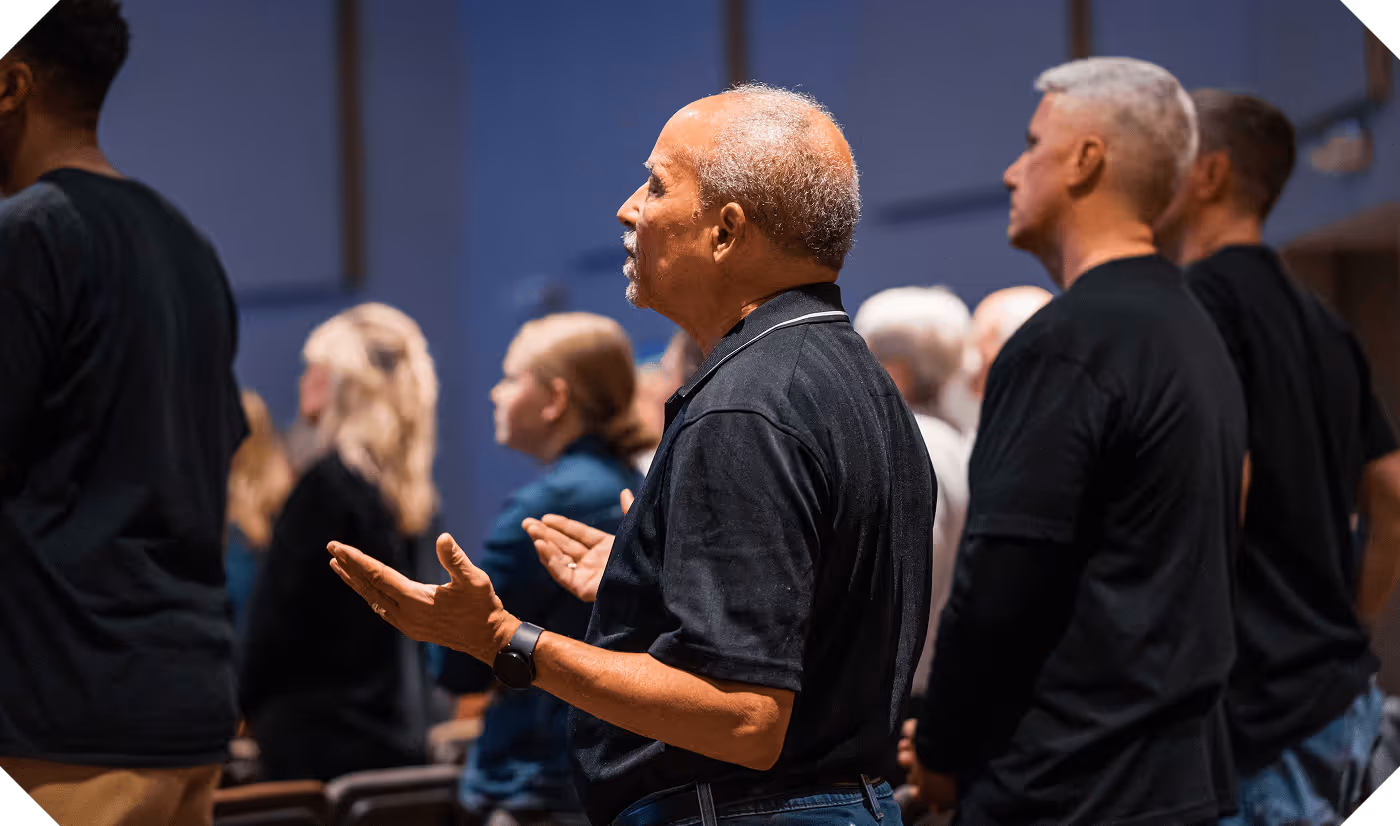 A man with arms raised during worship