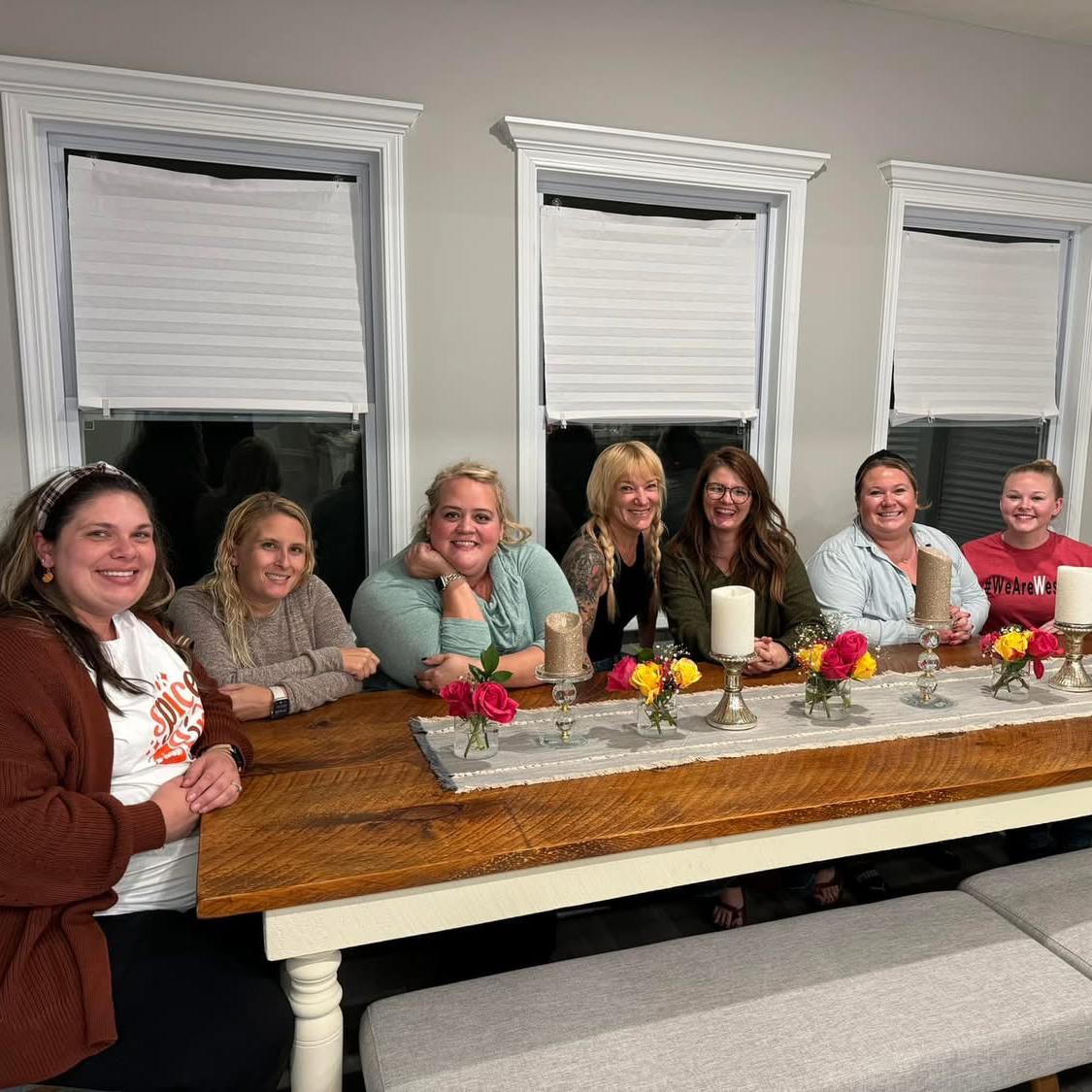 Seven women sitting together around a table