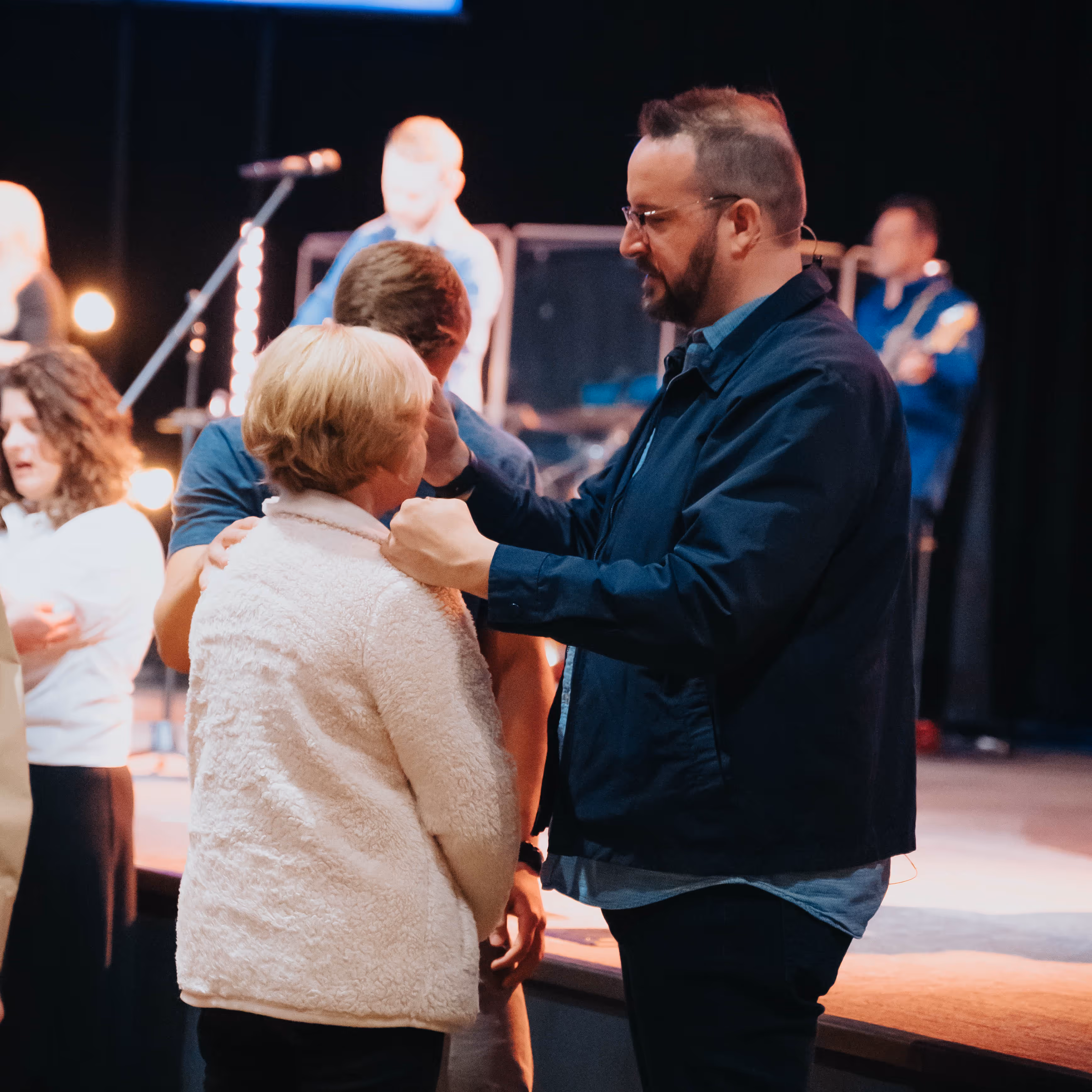 A woman receiving prayer during service from a pastor
