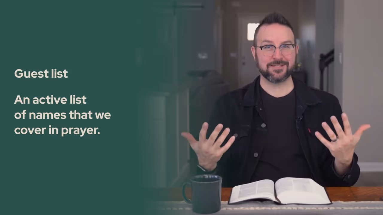 a man sitting at a table with a book and a mug