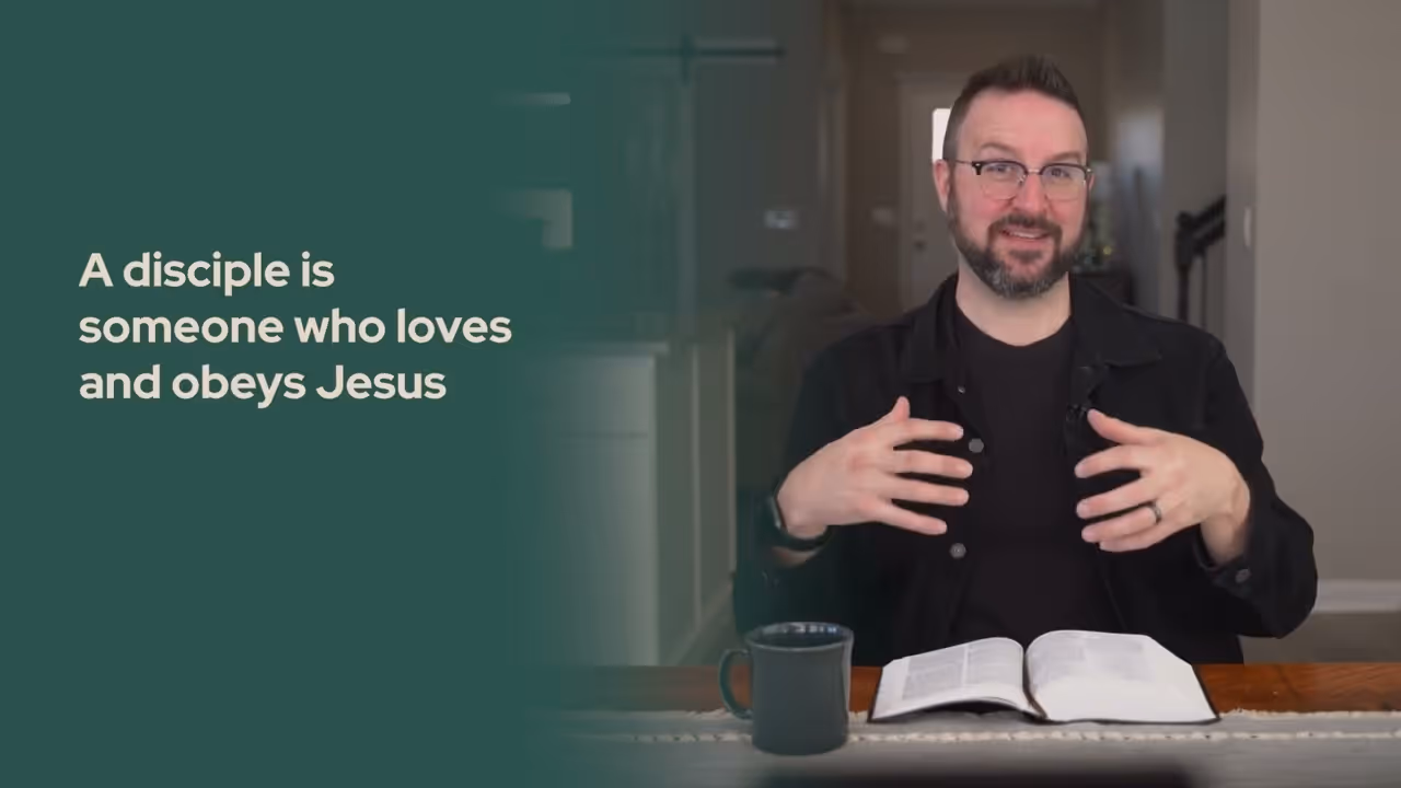 a man sitting at a table with a book and a mug