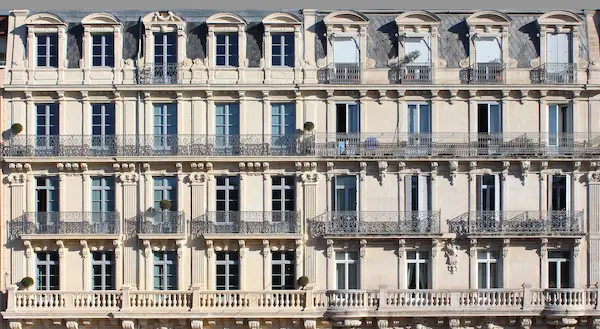 Façade haussmannienne typique avec balcons à Paris – Home Select, chasseur immobilier.