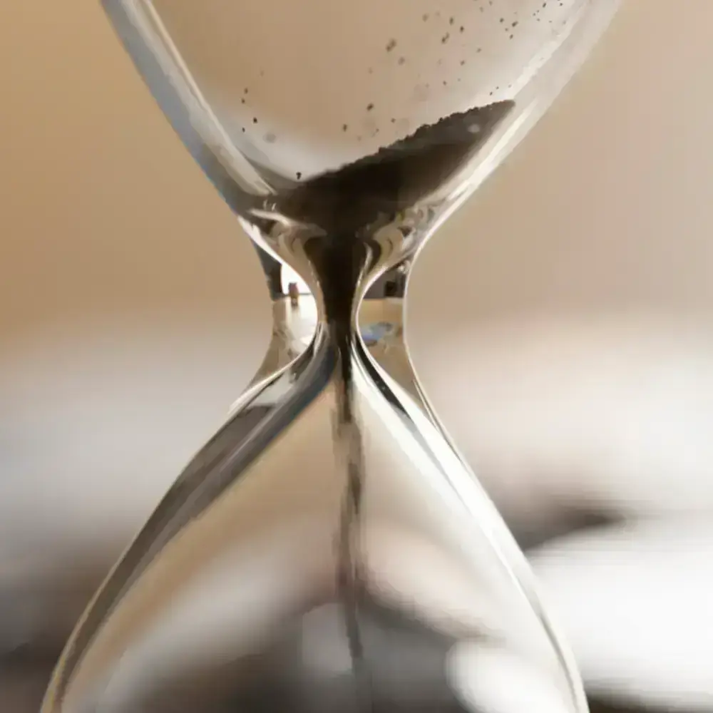 Image d'une sablier avec du sable à l'intérieur qui s'écoule