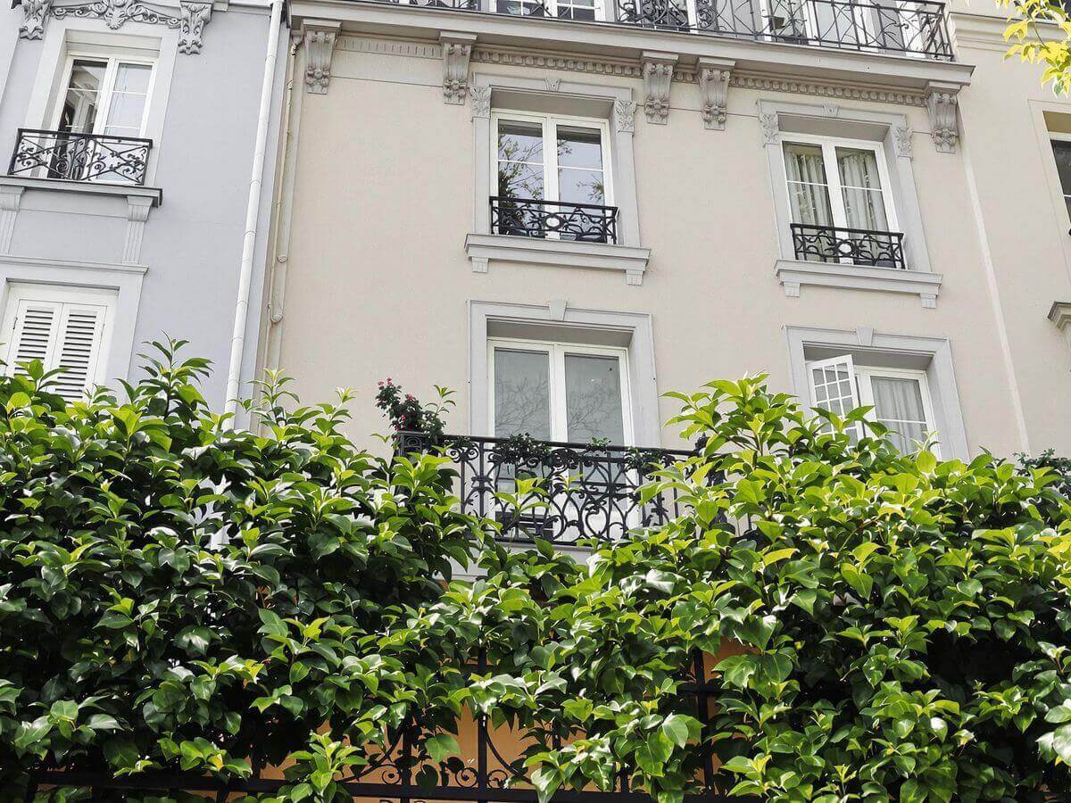Appartement parisien avec balcon et verdure environnante.