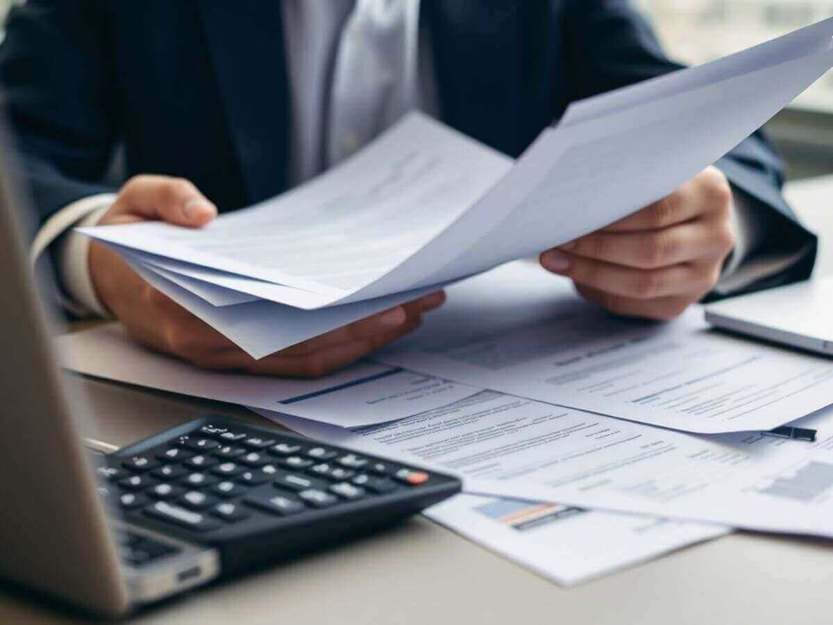 Personne analysant des documents financiers dans un bureau moderne.