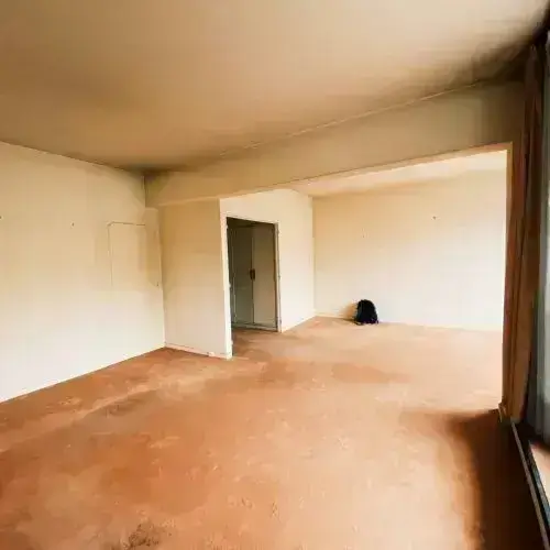Empty room with wooden floor, white walls, and open door