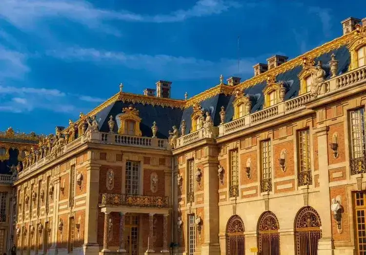 Palais élégant à Versailles, avec détails architecturaux raffinés et ciel bleu.