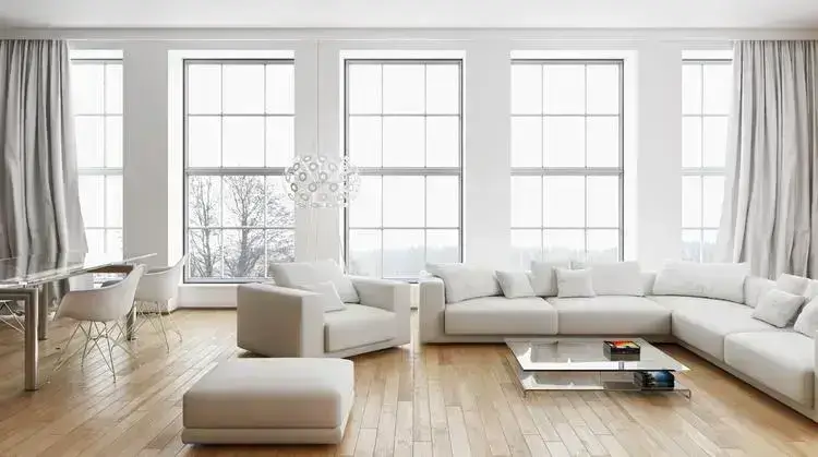 Salon moderne et lumineux d'un appartement de luxe à Paris, avec de grandes fenêtres et un mobilier contemporain.
